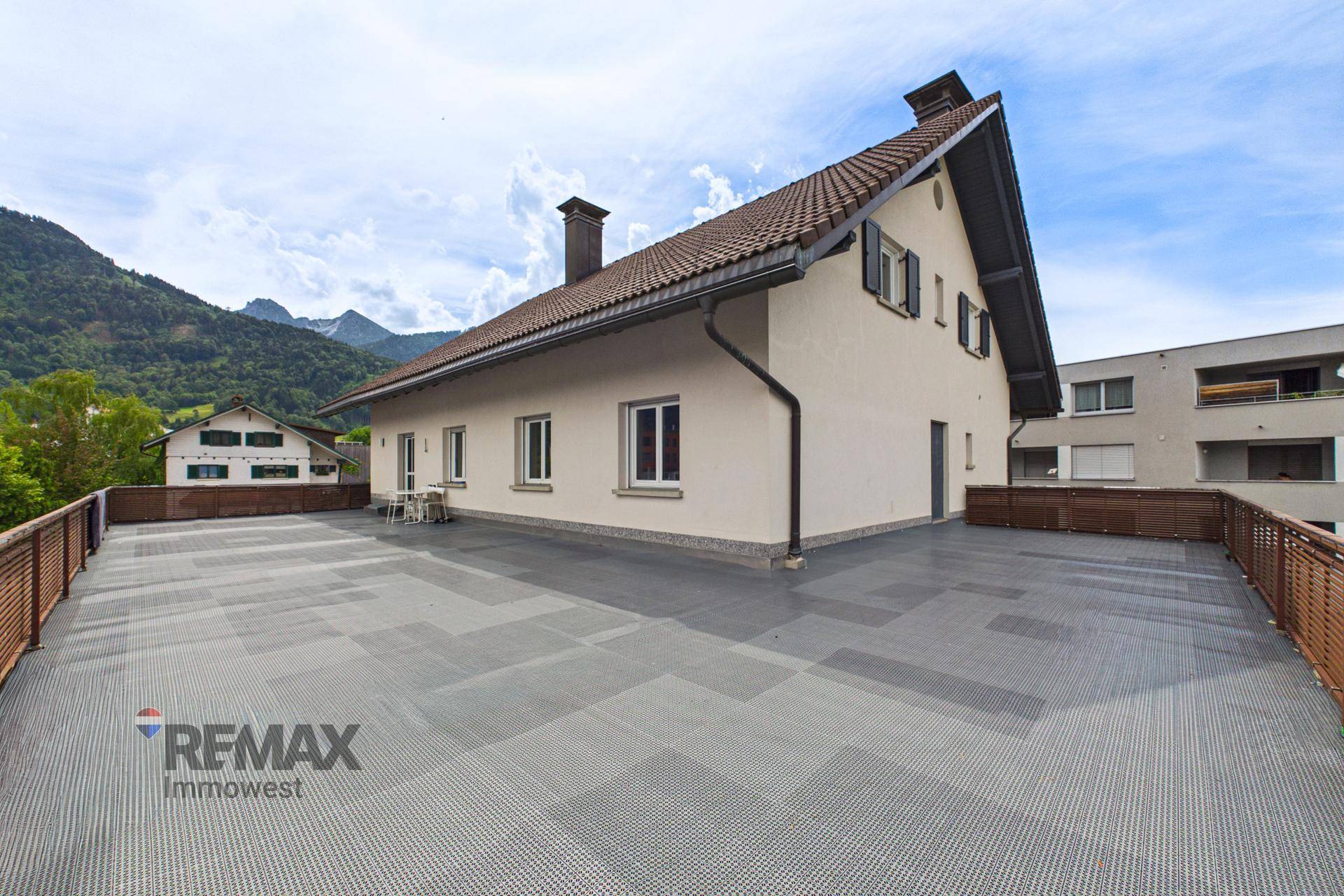 Weitläufige Dachterrasse mit Blick auf die Berge und das umliegende Wohngebiet.