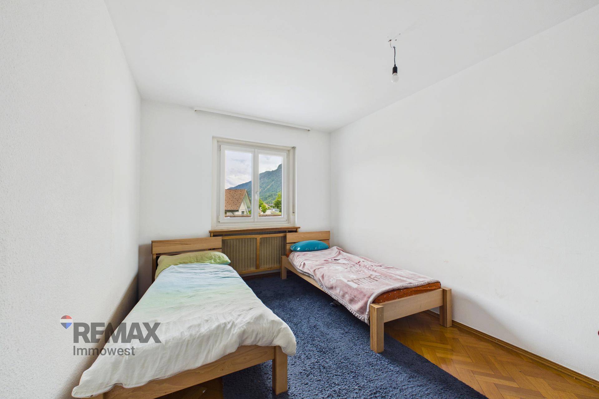 Freundliches Schlafzimmer mit zwei Einzelbetten und einem schönen Blick auf die Berge.