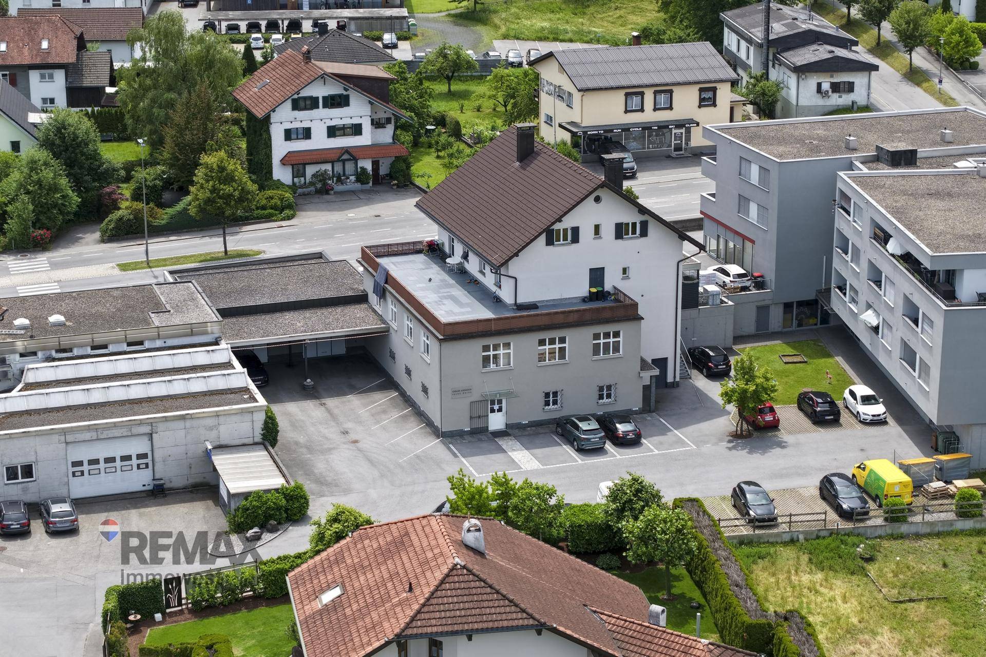 Vogelperspektive des Gebäudes mit angrenzenden Parkplätzen und Grünflächen.