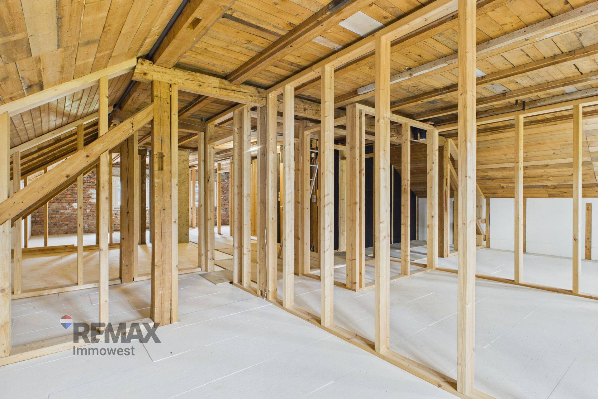 Dachgeschoss im Ausbau mit Holzkonstruktion und vorbereitetem Boden.