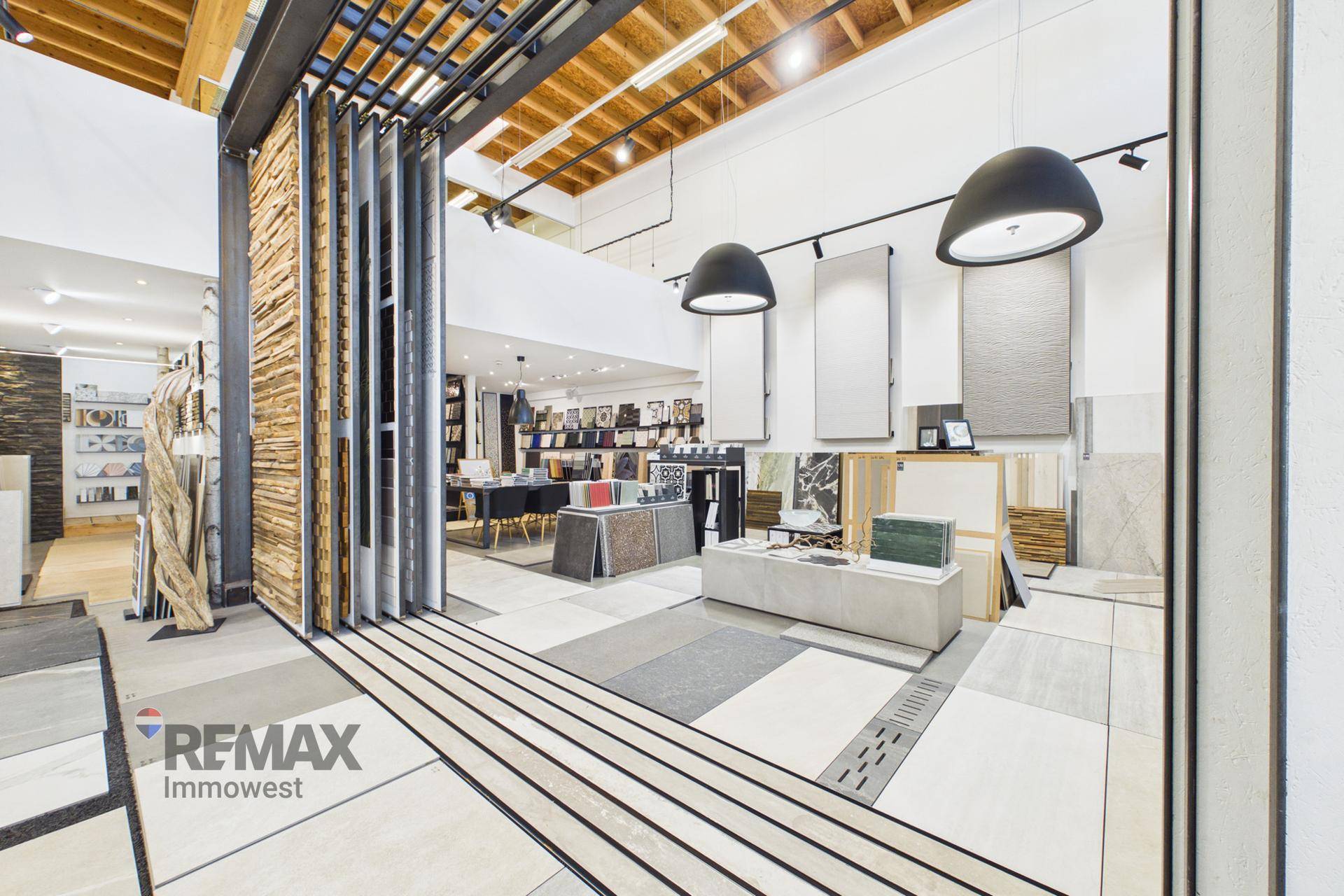 Offener Bereich im Showroom mit einer beeindruckenden Auswahl an Fliesen und einer markanten Holzlamellenwand.