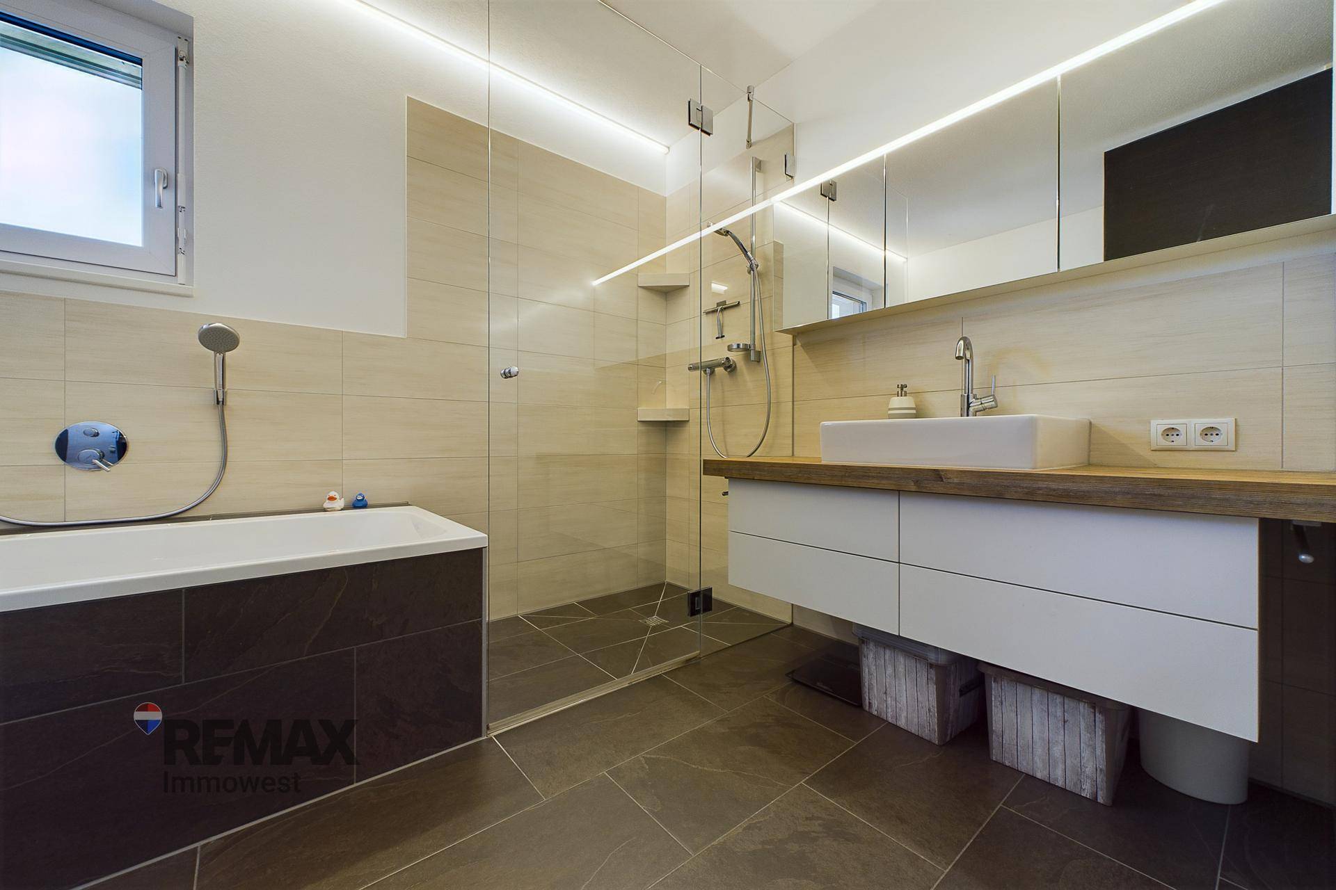 Modernes Badezimmer mit begehbarer Dusche, Badewanne und großem Waschtisch.
