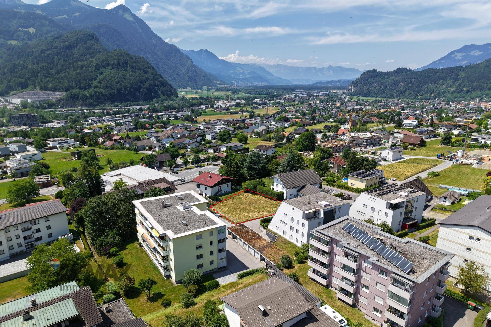 Panoramische Luftaufnahme des Baugrundstücks mit Blick auf die Stadt und die umliegenden Berge.