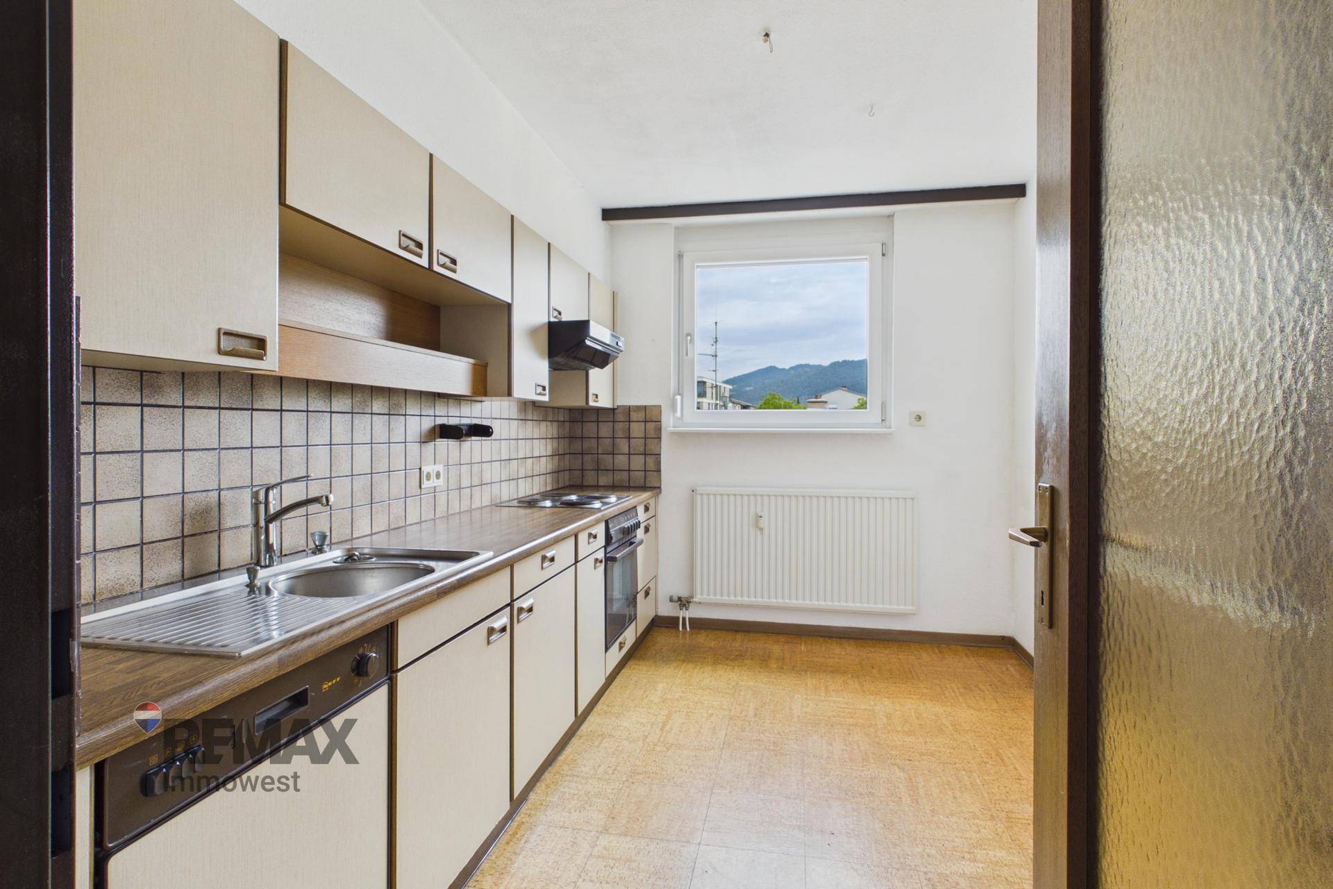 Küche im traditionellen Stil mit Einbauschränken, Fliesen und Fenster mit Bergblick.