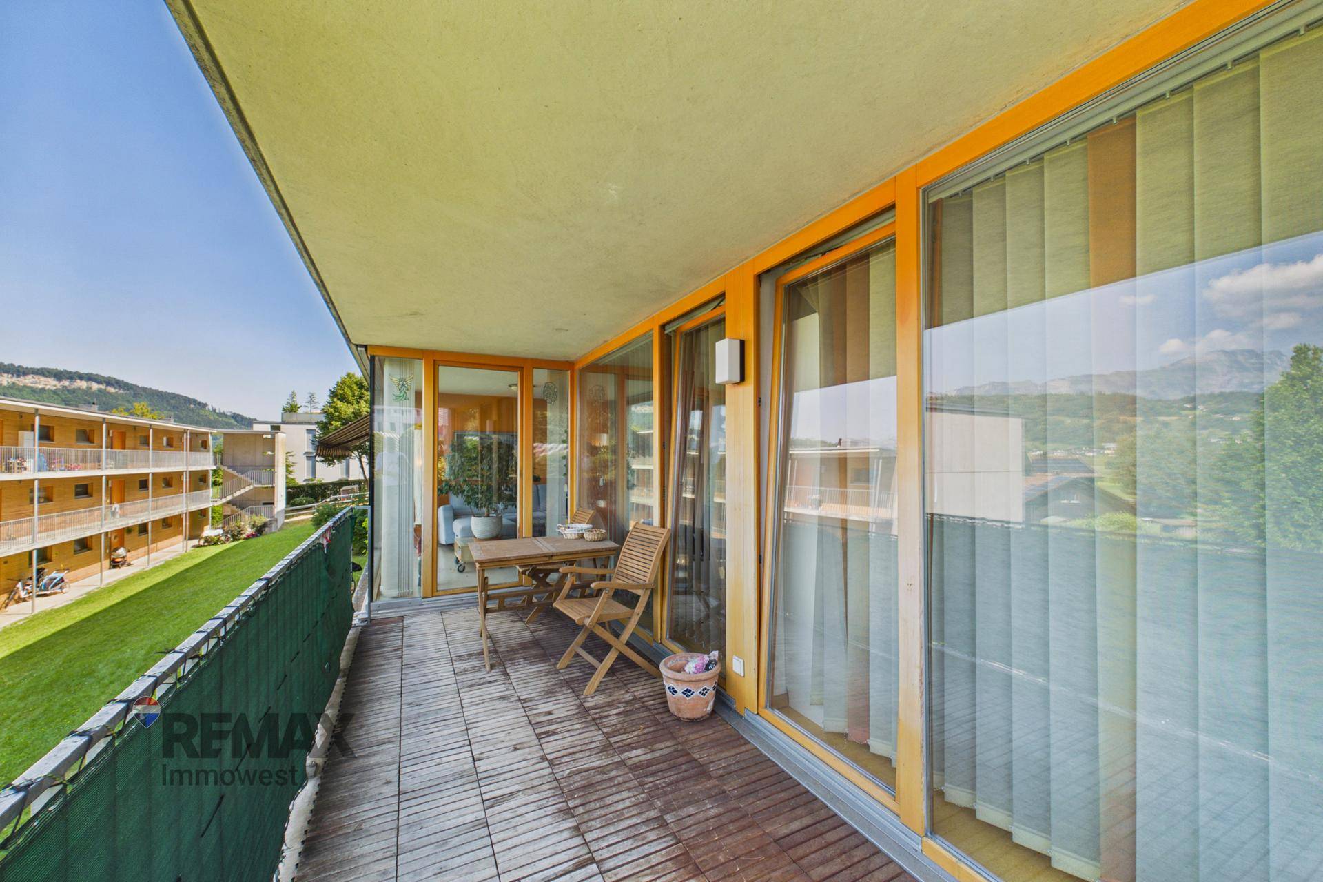Geräumiger Balkon mit Holzboden und Sitzgelegenheiten, bietet einen weiten Blick auf die Umgebung.