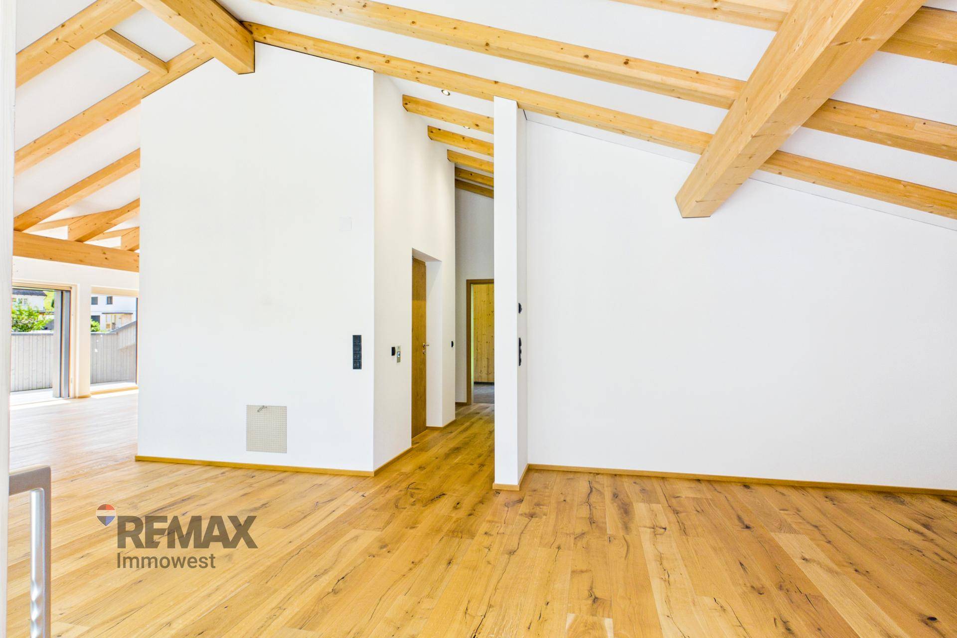 Offener Raum mit hohen, schrägen Decken und sichtbaren Holzbalken, ideal für individuelle Gestaltung.