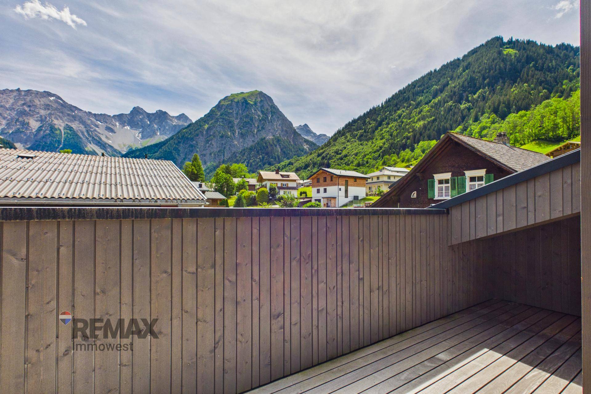 Balkon mit Holzwänden und malerischem Blick auf die umliegende Berglandschaft.