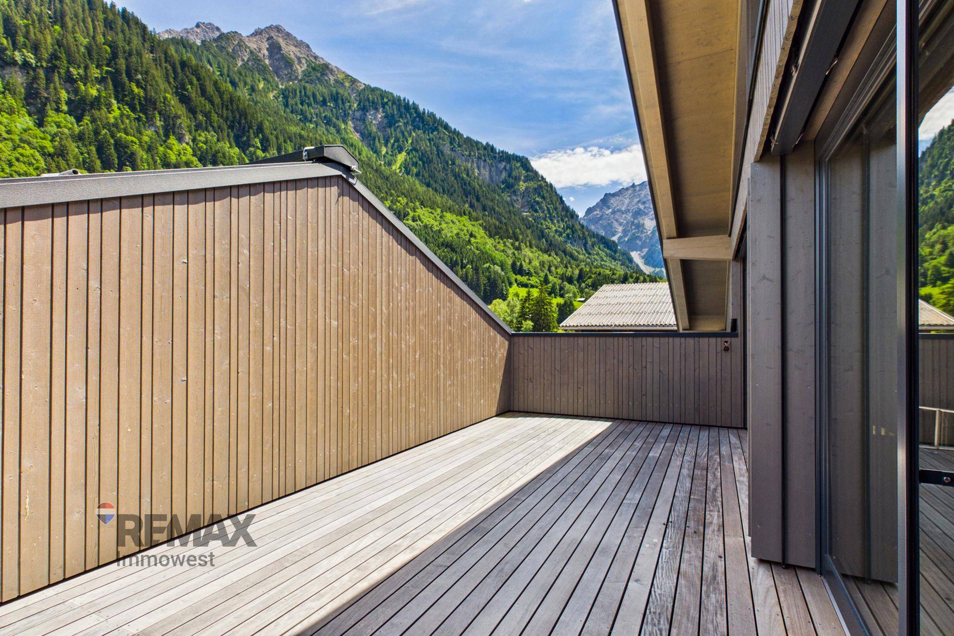 Breite Holzterrasse mit Holzwänden, ideal zum Entspannen im Freien.