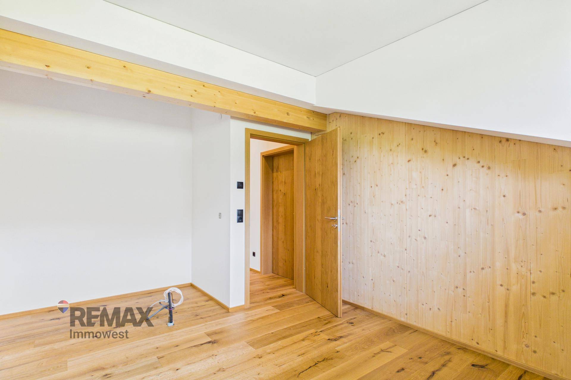 Gemütlicher Raum mit Holzwänden und Holzboden, bereit für die individuelle Gestaltung.