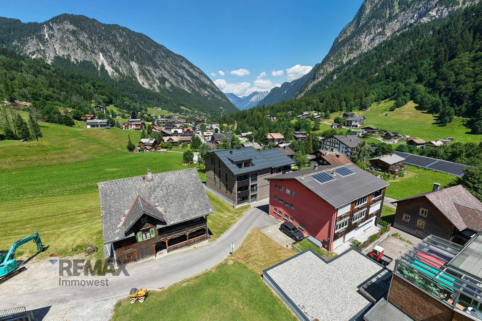 Weitläufige Luftaufnahme eines Tals mit mehreren Gebäuden und Bergen.