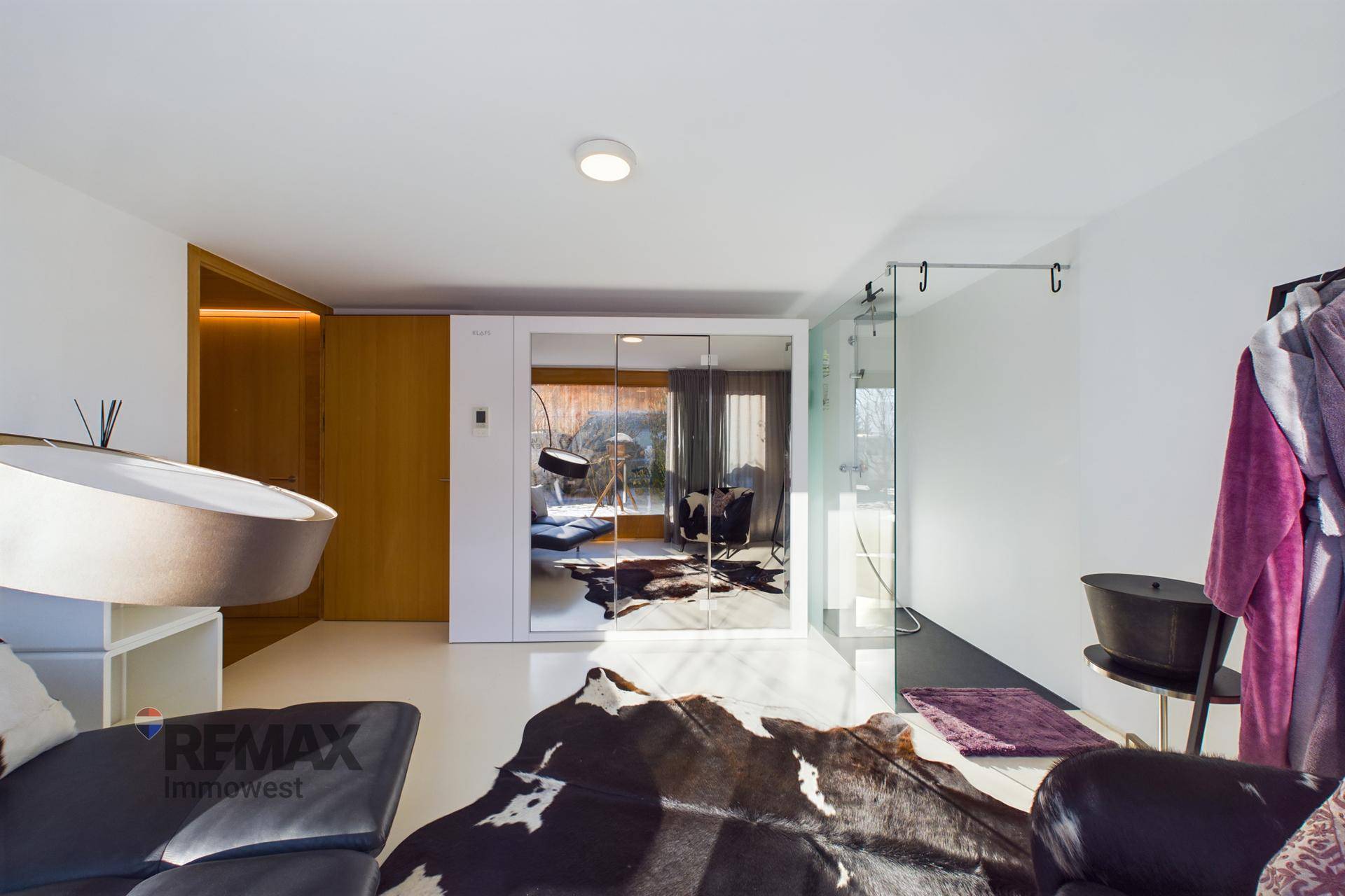 Heller Raum mit Spiegelschränken, Glasabtrennung und modernem Interieur.