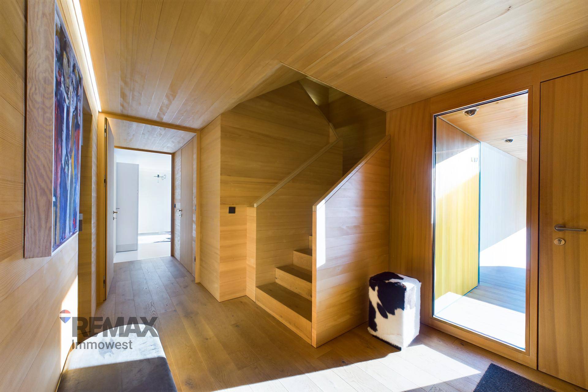 Eingangsbereich mit Holztreppe, Holzwänden und modernem Design.
