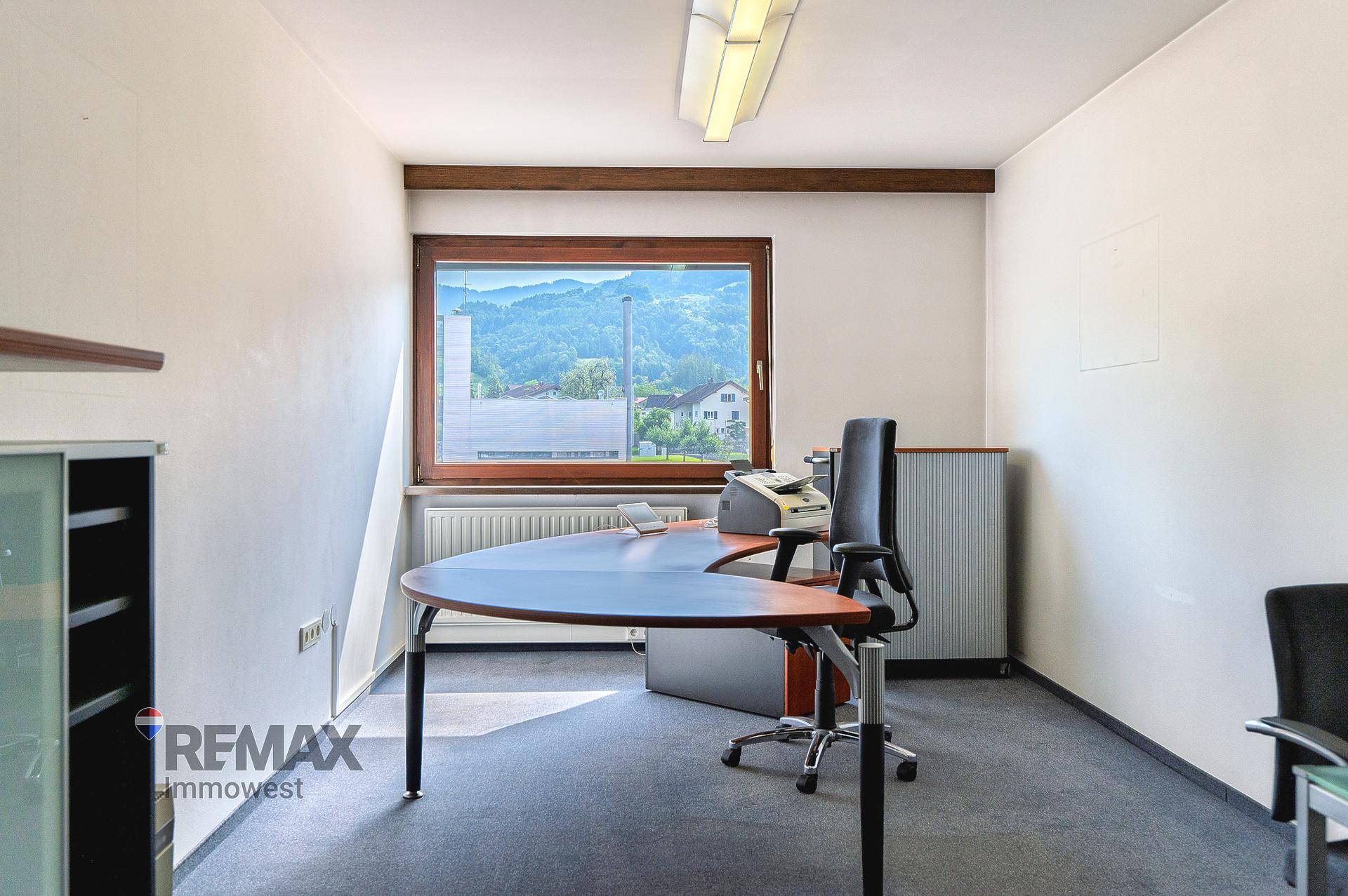 Funktionales Büro mit Schreibtisch, Bürostuhl und Fenster mit Blick auf die Umgebung.