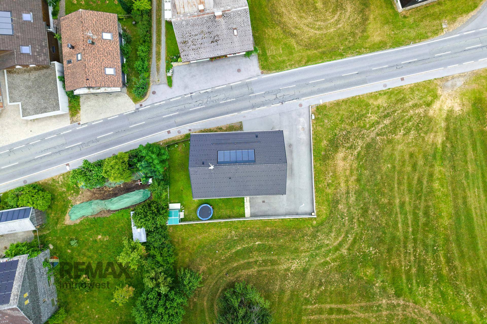 Luftaufnahme des Hauses mit Dachfenstern, umgeben von grünen Feldern.