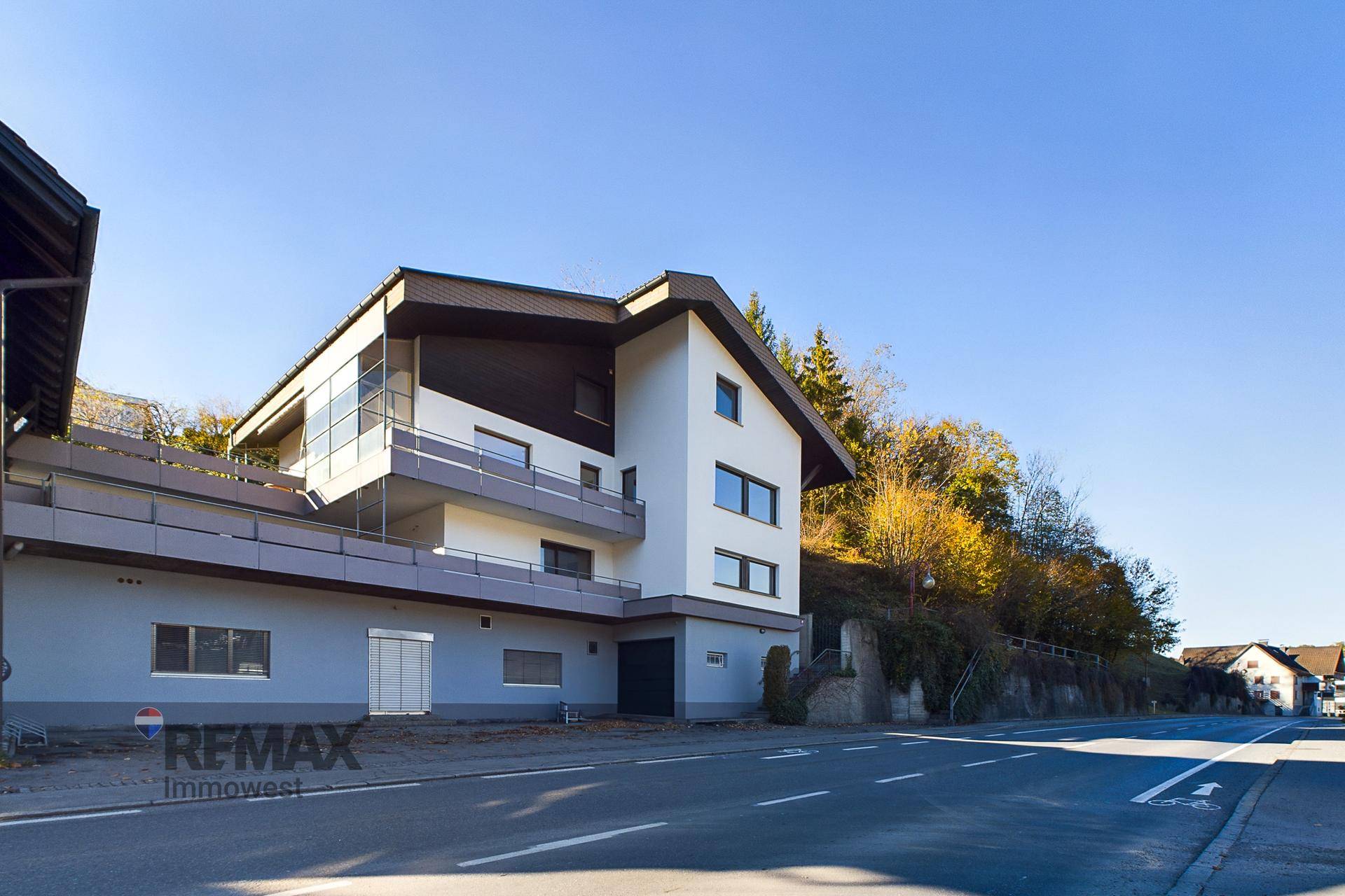 Mehrstöckiges Gebäude mit moderner Architektur, großen Fenstern und Balkonen an einer Straße gelegen.