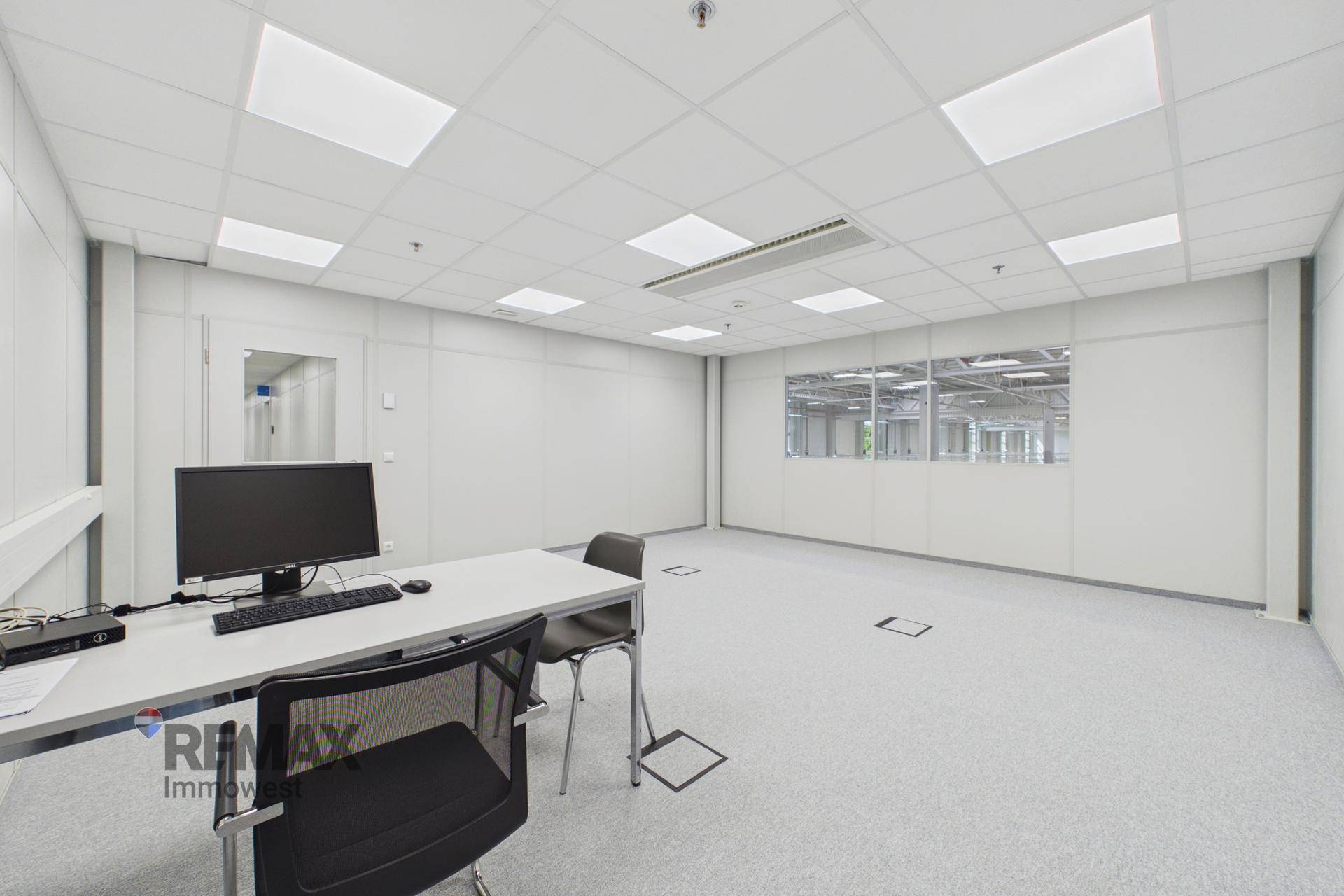 Geräumiges Einzelbüro mit moderner Einrichtung, hellem Teppichboden und Blick auf die Arbeitsbereiche.