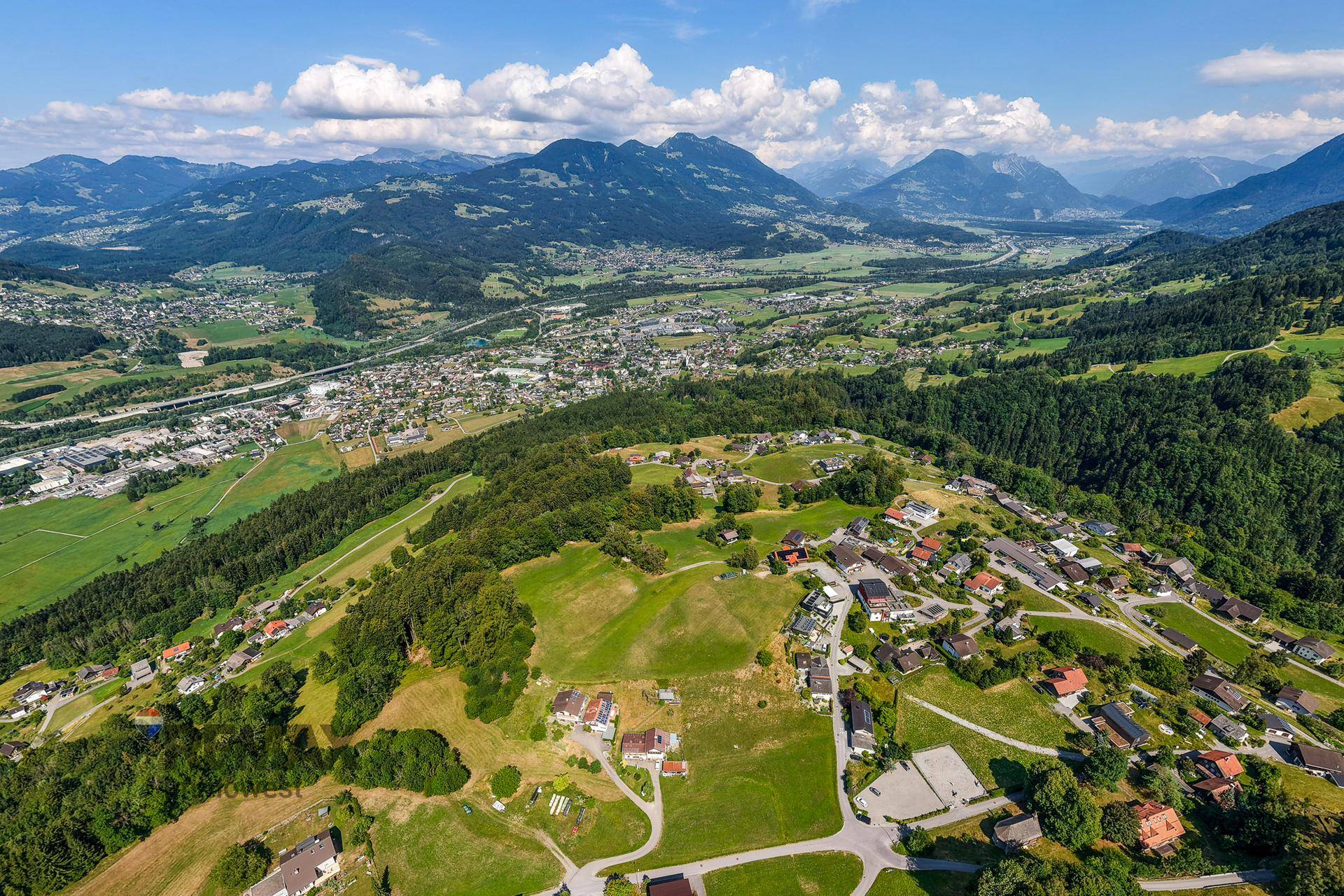 Umfassende Luftaufnahme einer ländlichen Region mit Wohngebieten und einem weiten Blick auf das Tal.