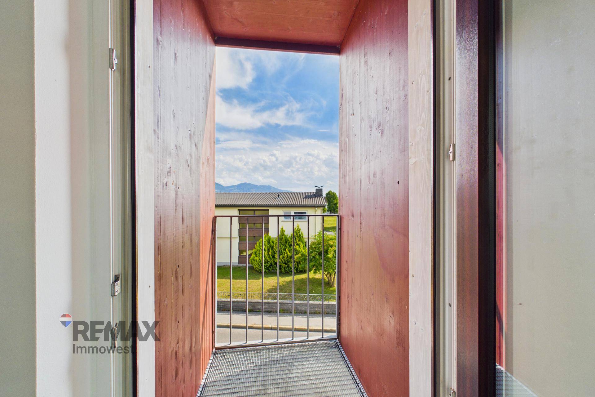 Kleiner, überdachter Balkon mit Metallgeländer und Bergblick.