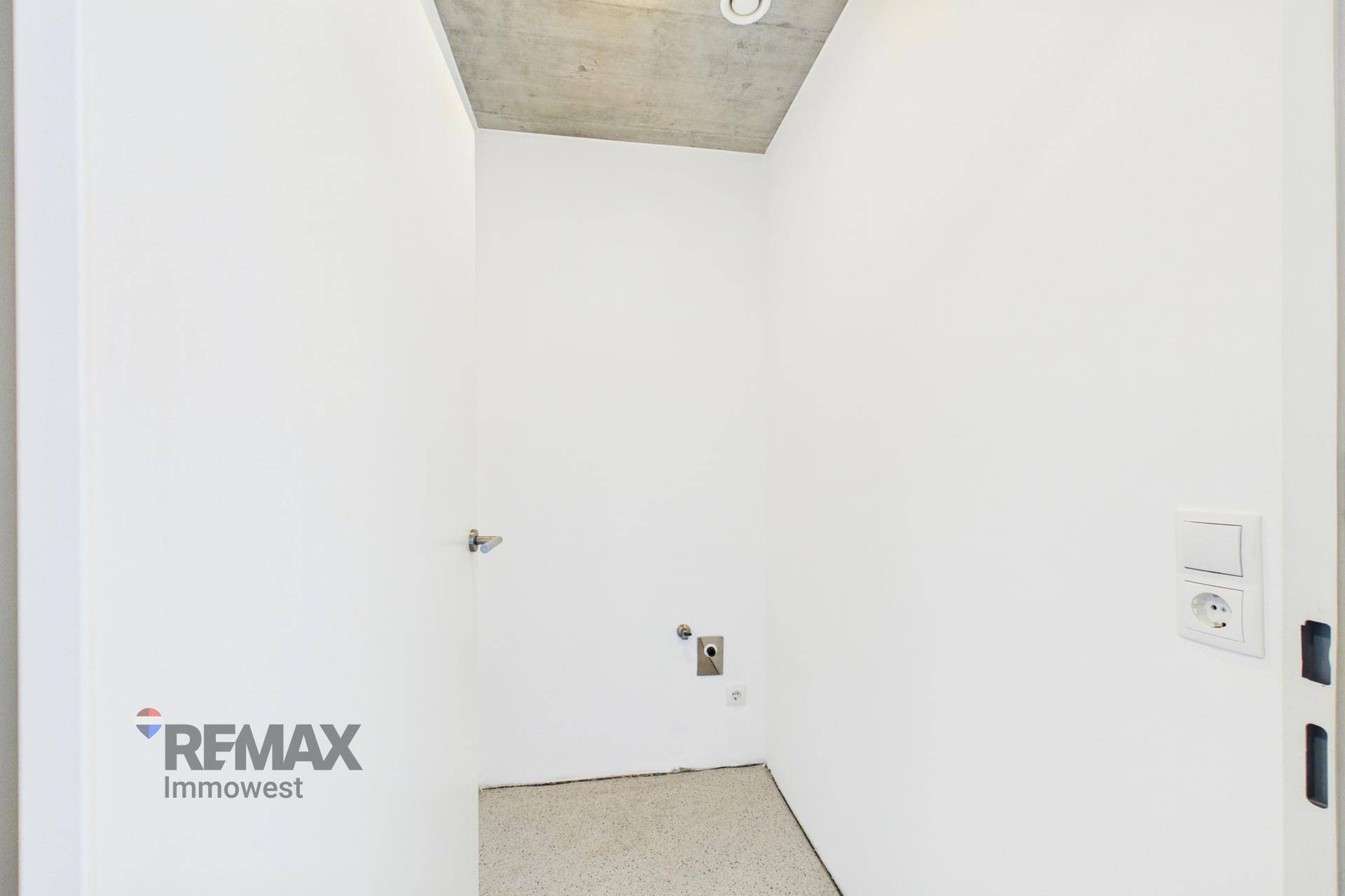 Praktischer Hauswirtschaftsraum mit Anschlüssen für Waschmaschine und Trockner.