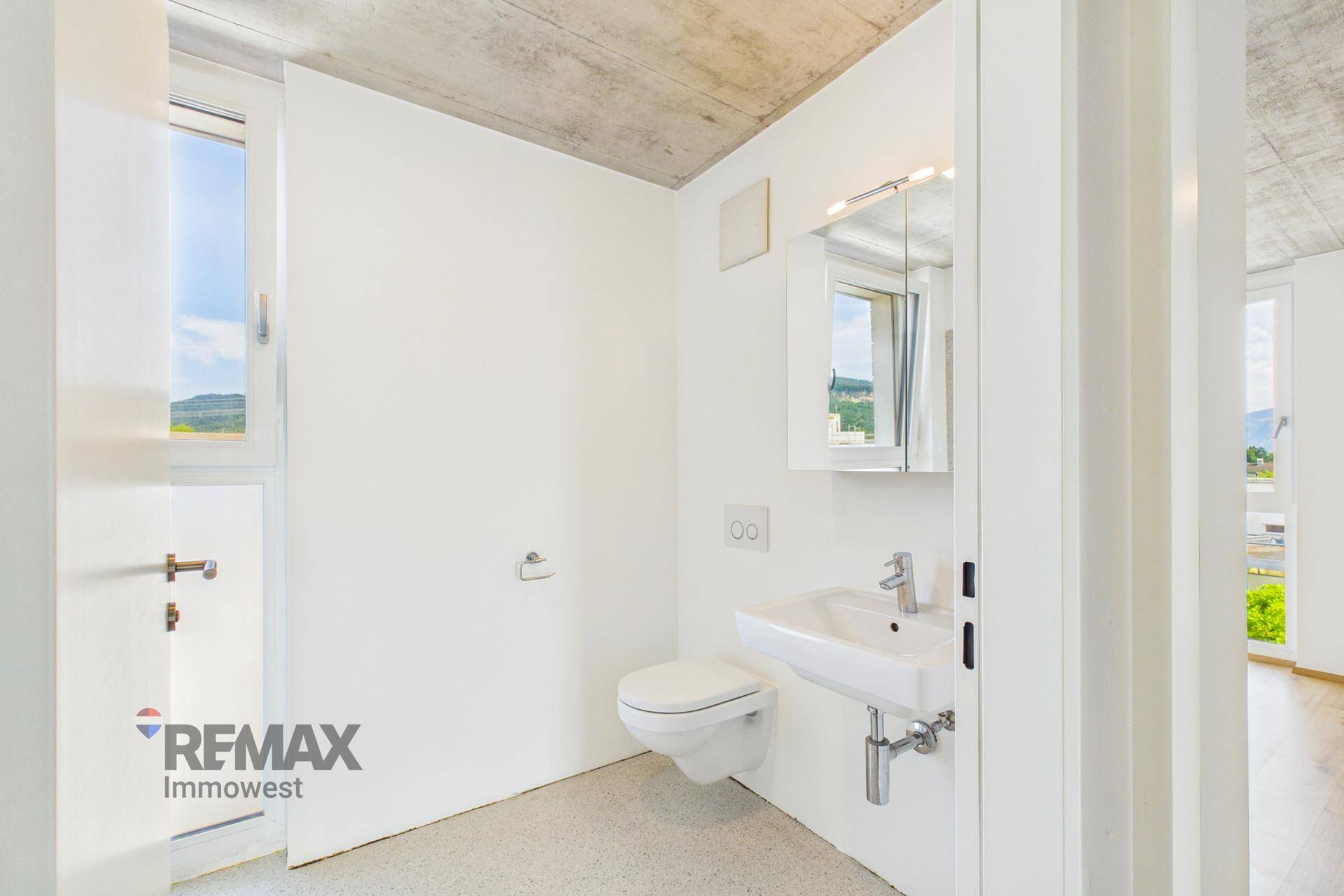 Modernes Gäste-WC mit wandhängender Toilette, Waschbecken und Spiegelschrank.