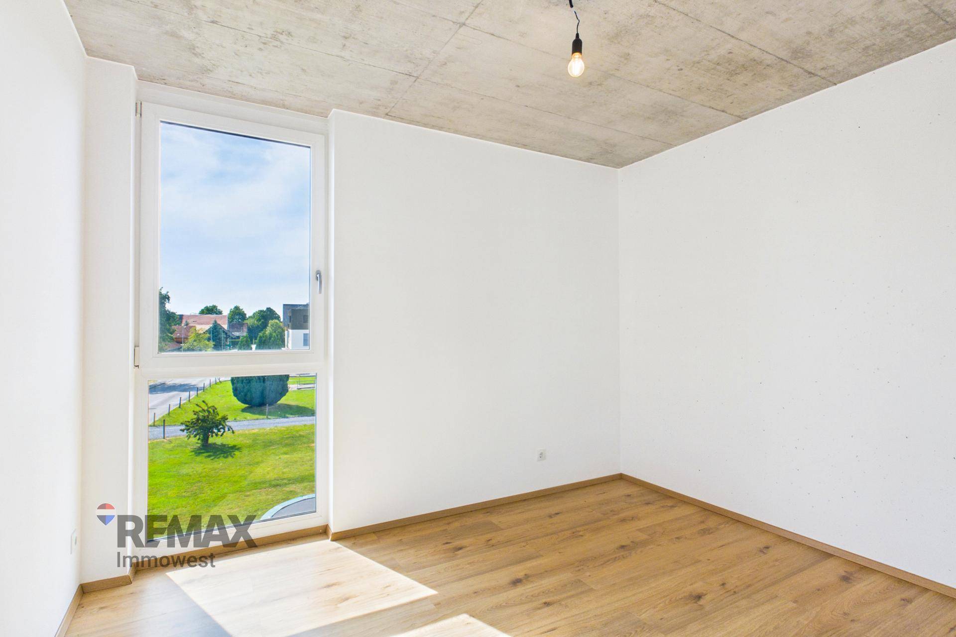Freundliches Schlafzimmer mit Parkettboden und weitem Blick ins Grüne.
