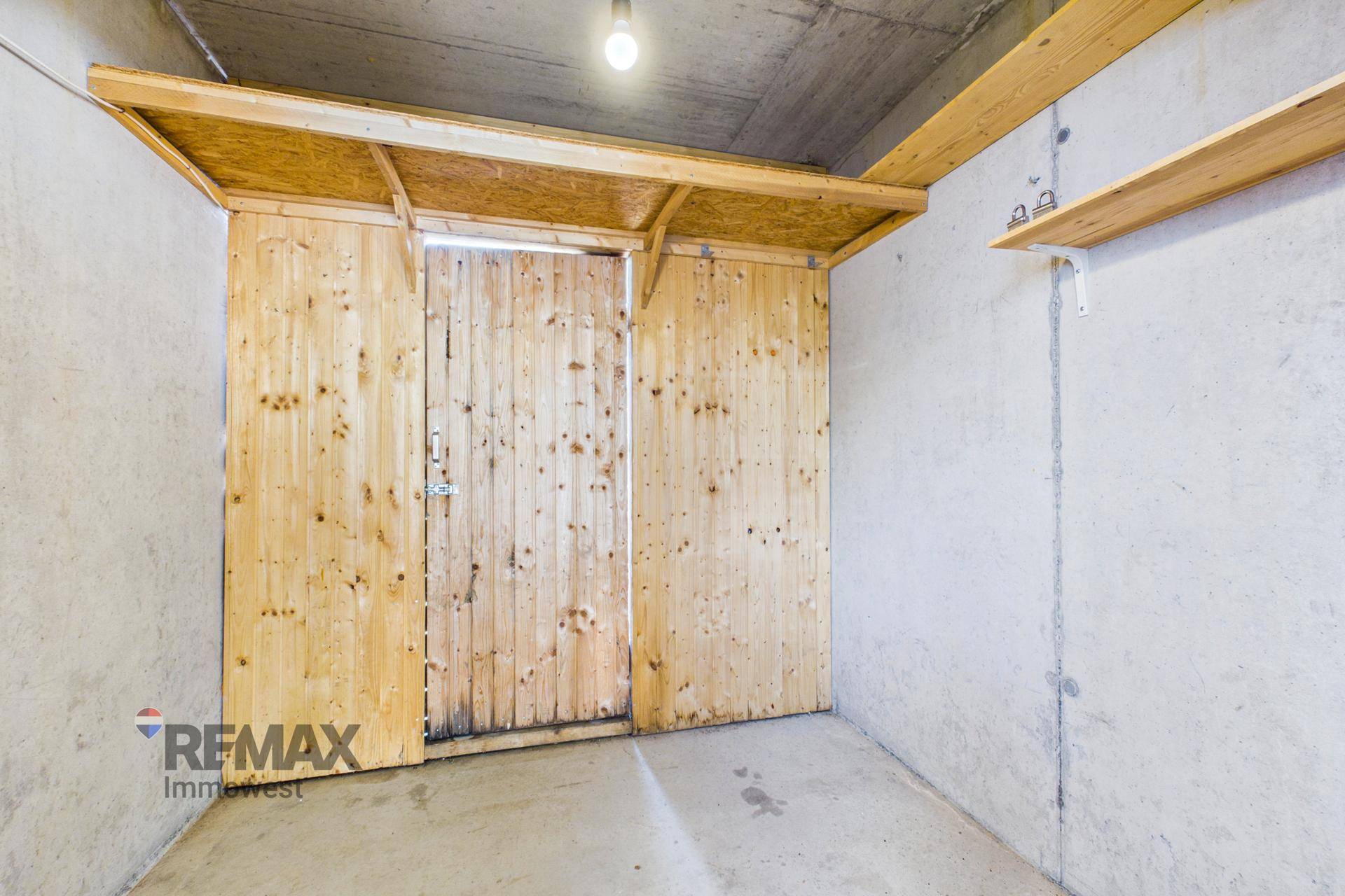 Abstellraum mit Holzwänden und Betonboden, ideal für zusätzlichen Stauraum.