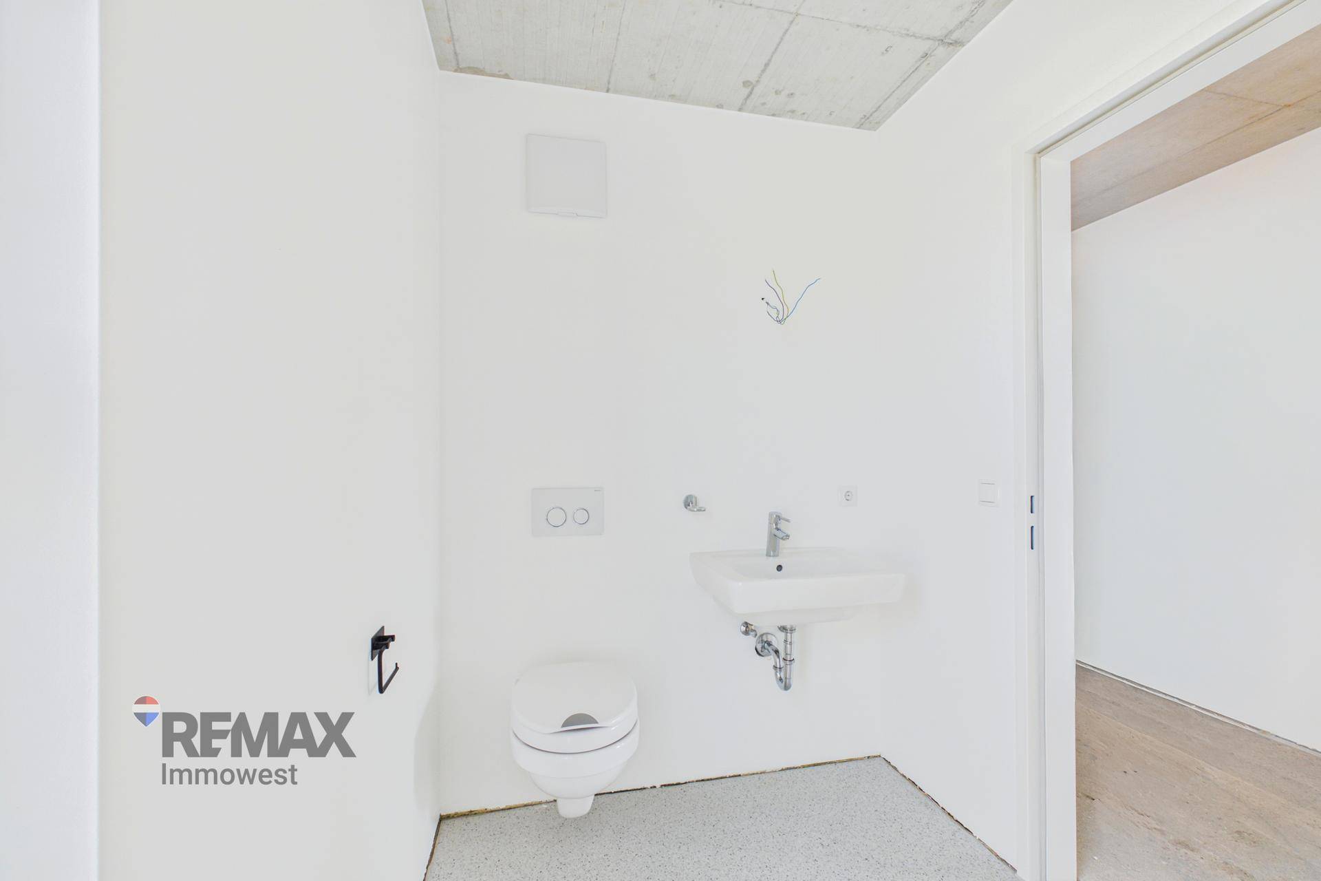 Kleines WC mit wandhängender Toilette und Handwaschbecken, ideal als Gästetoilette.