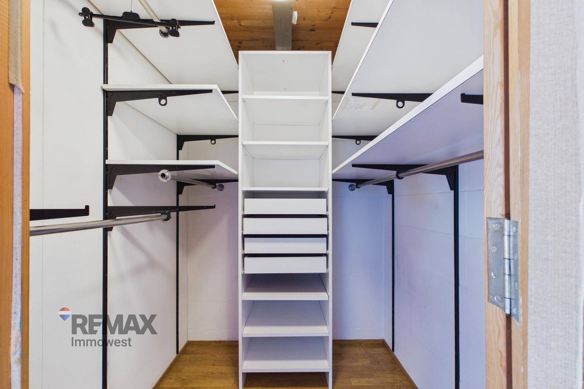 Begehbarer Kleiderschrank mit Regalen und Kleiderstangen für optimale Organisation.