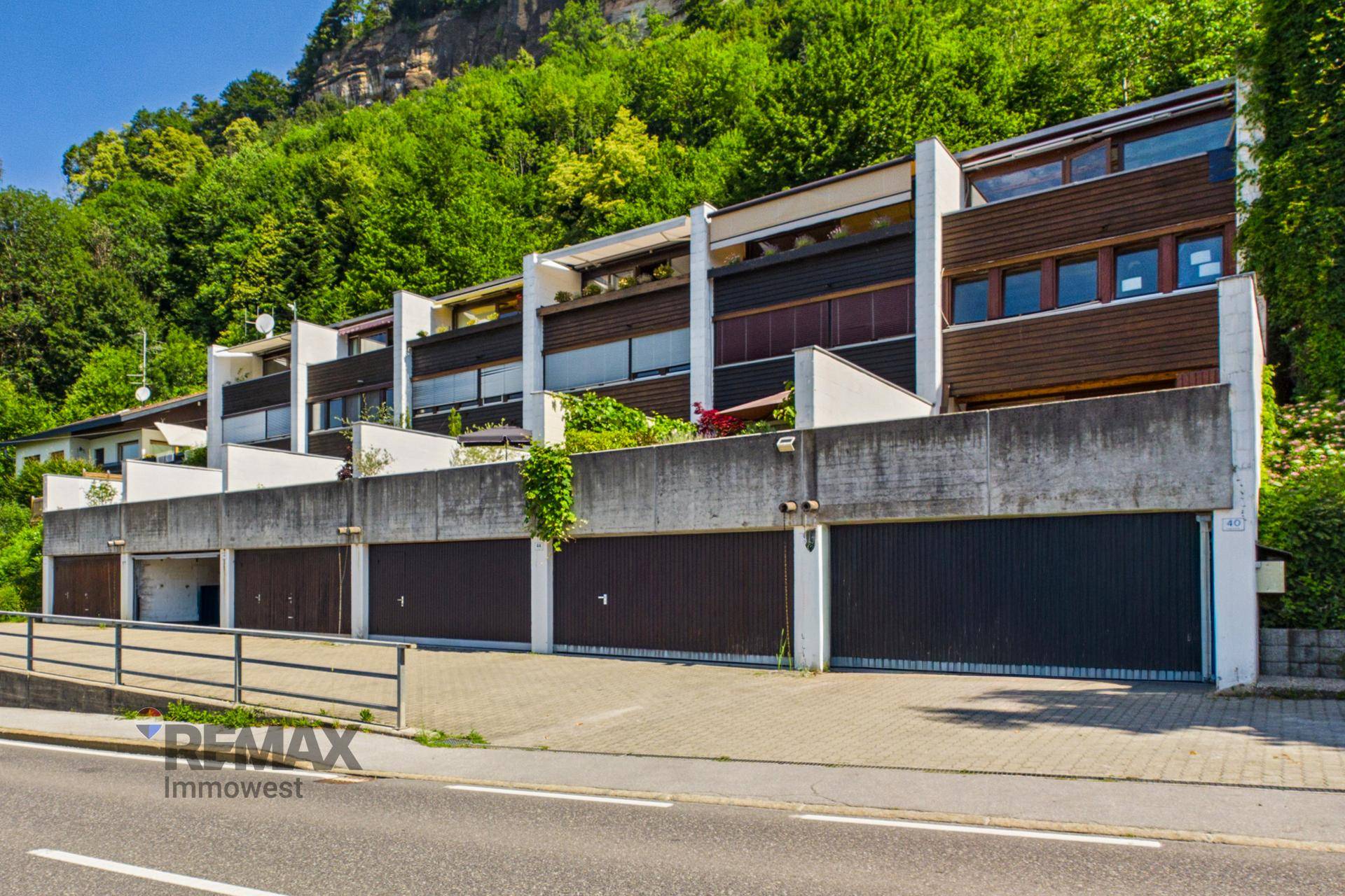 Ansicht der Garagenreihe und der darüber liegenden Wohngebäude mit moderner Architektur.