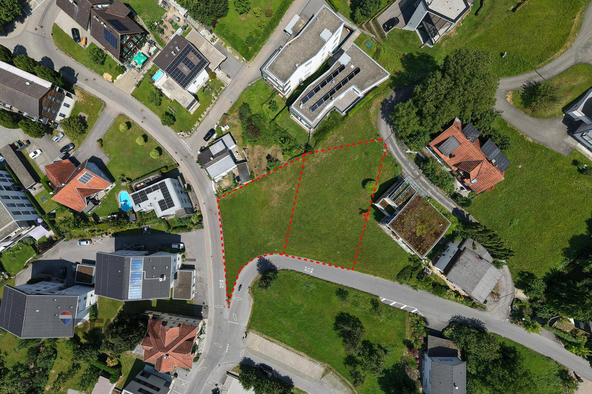 Senkrechte Luftaufnahme des Baugrundstücks und der umliegenden Bebauung mit Straßennetz.