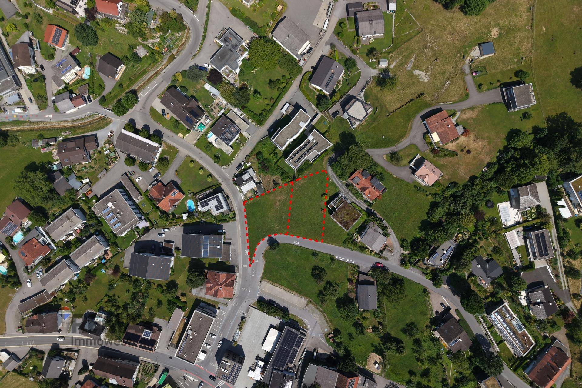 Weitläufige Draufsicht auf das Baugrundstück und die angrenzende Wohnbebauung in ländlicher Umgebung.