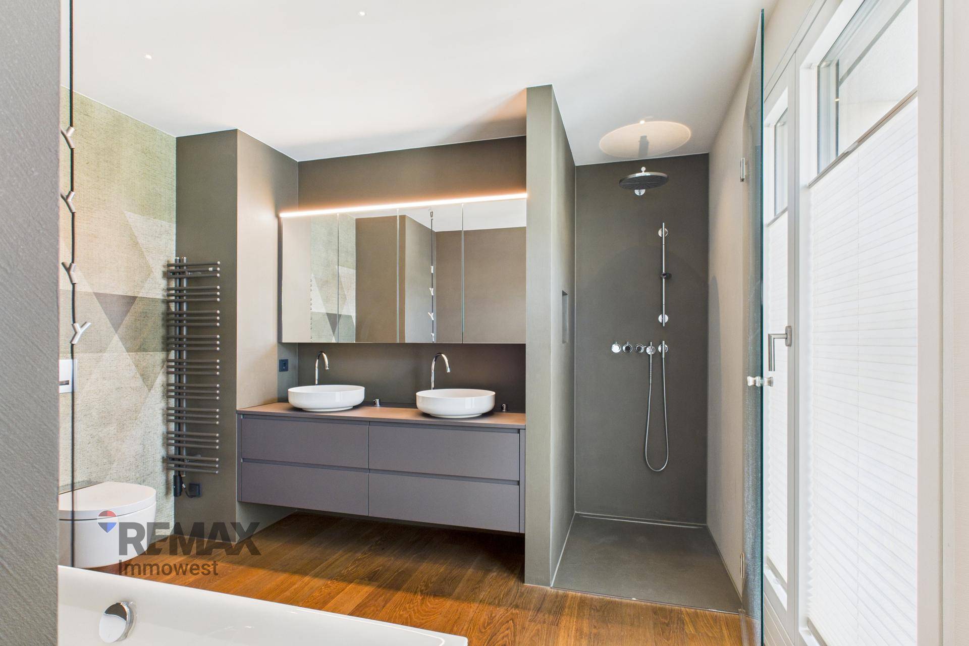 Modernes Badezimmer mit Doppelwaschbecken, großer Dusche und Badewanne.