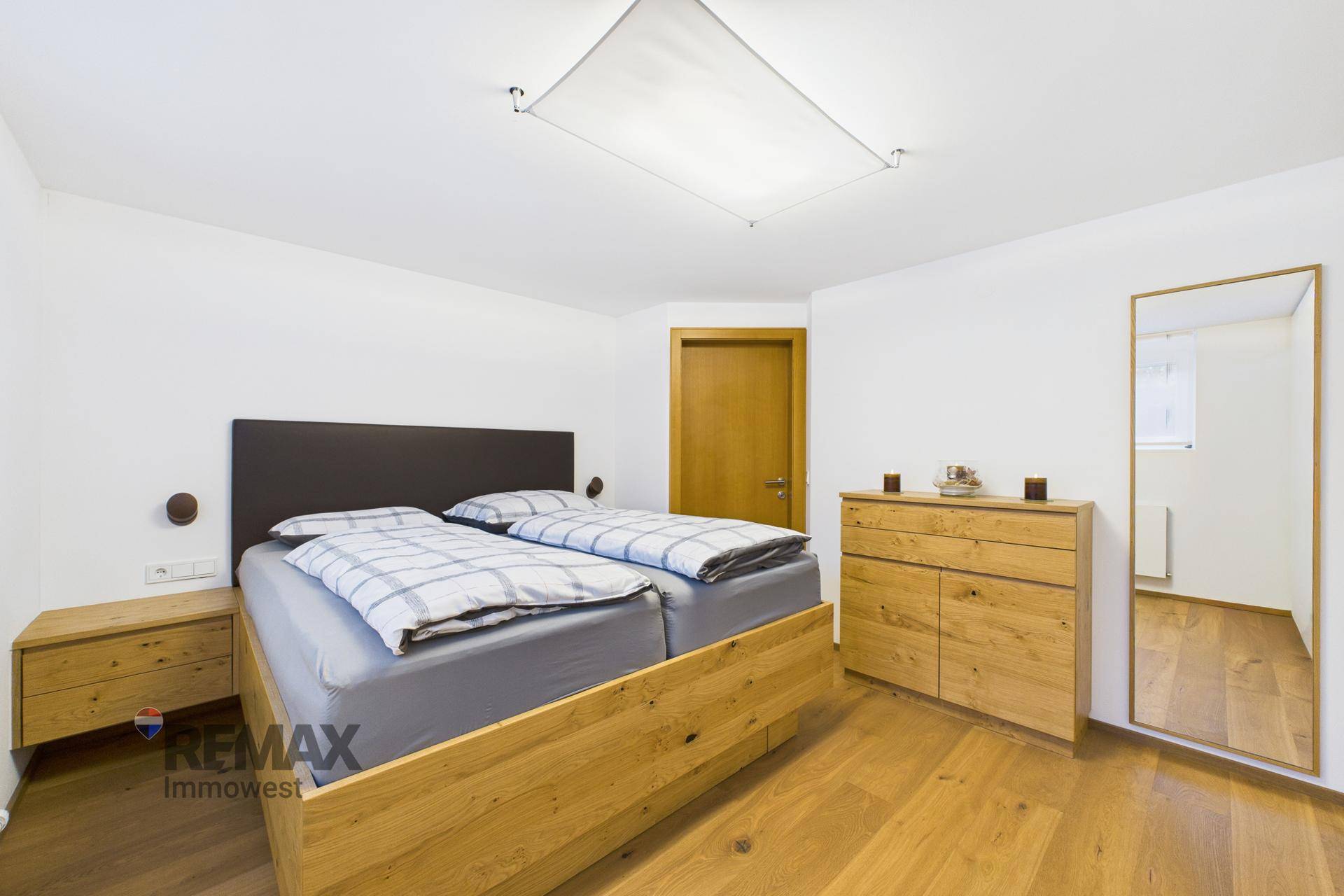 Gemütliches Schlafzimmer mit Holzbett, passenden Nachttischen und Holzfußboden.