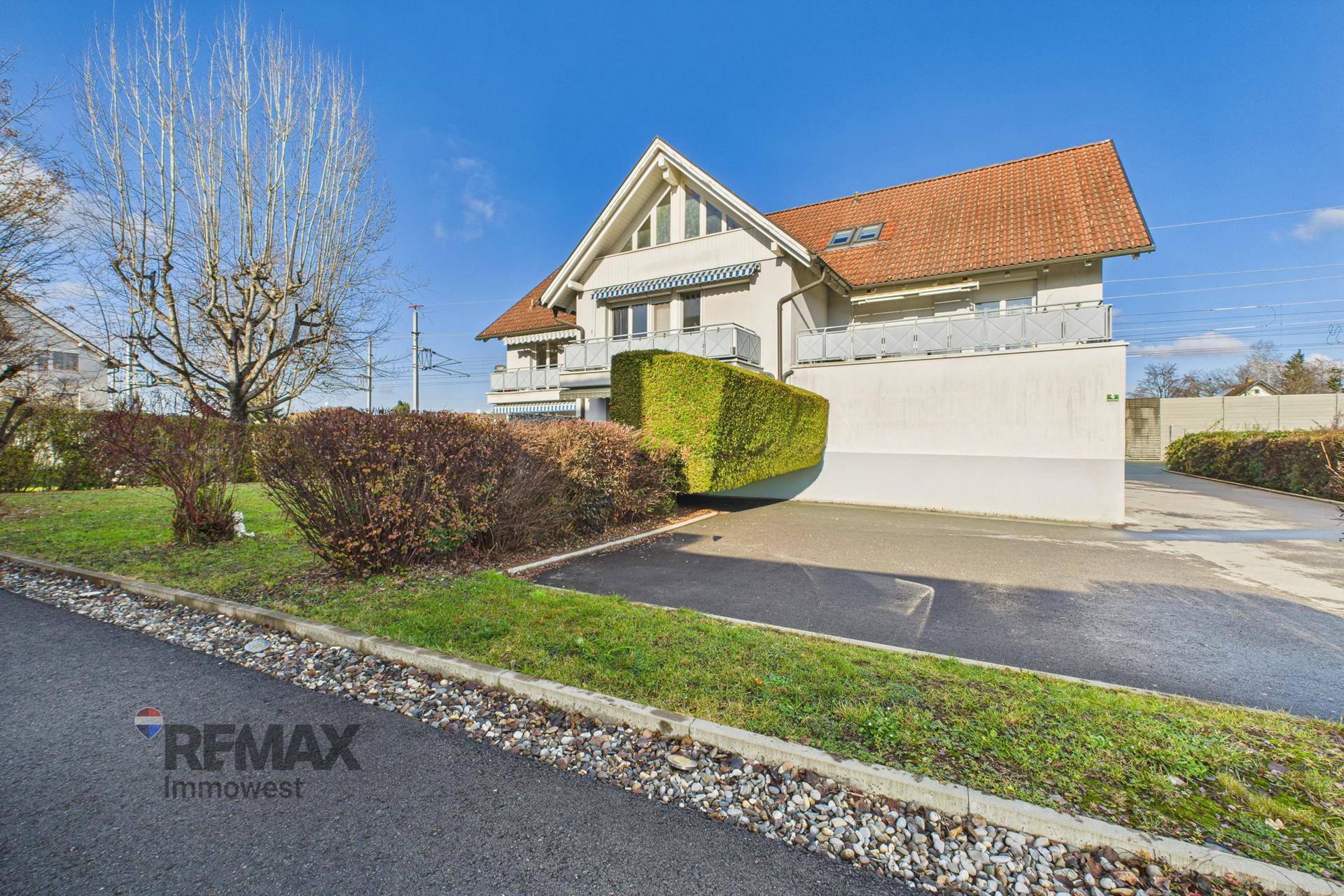 Außenansicht des Hauses mit Satteldach, gepflegtem Vorgarten und Zufahrt.