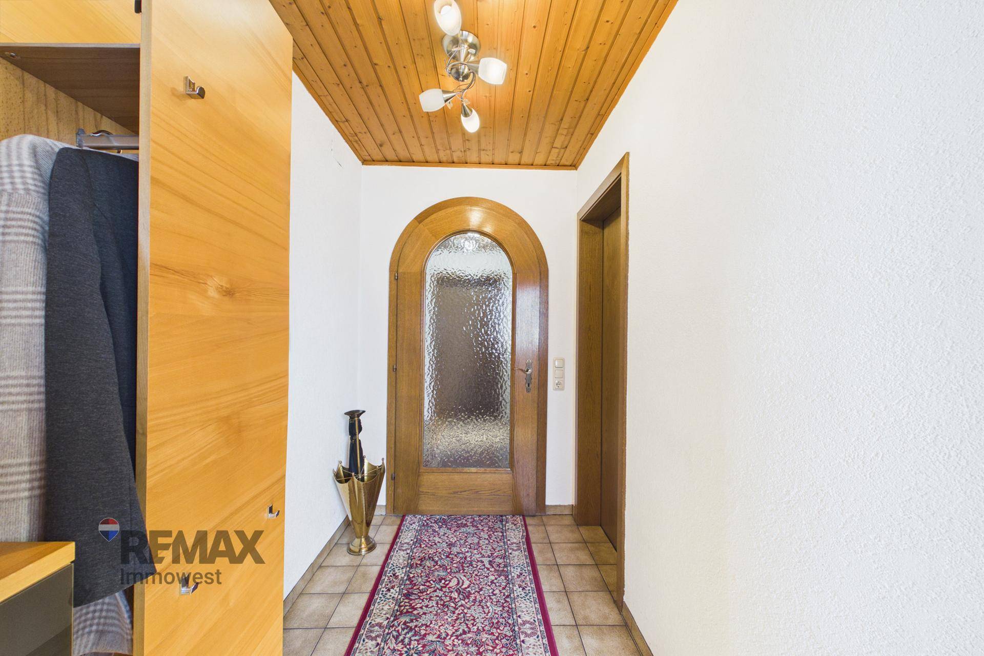 Gemütlicher Eingangsbereich mit Holzdecke, Fliesenboden und Garderobenschrank in traditionellem Stil.