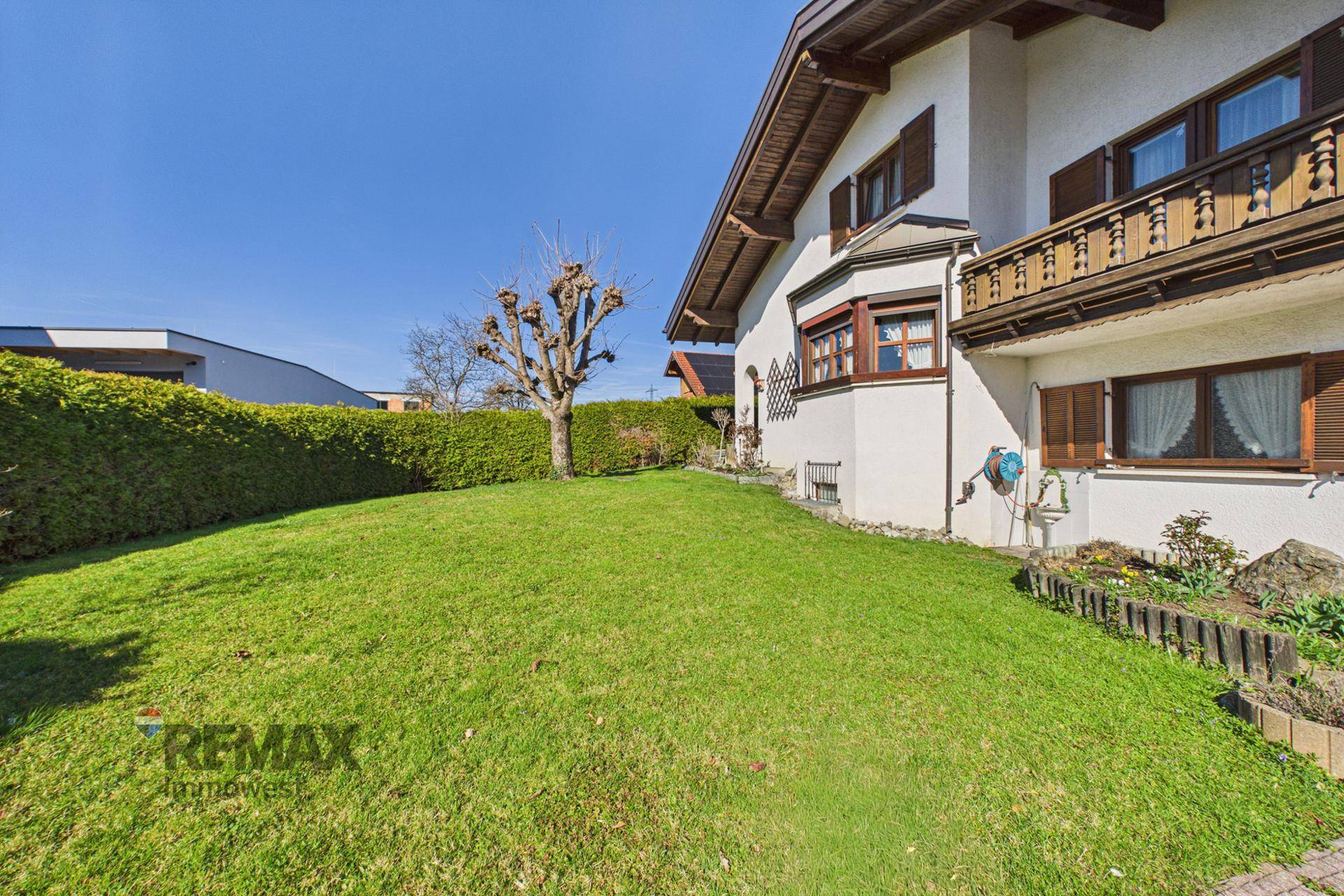 Großer, gepflegter Gartenbereich mit Rasenfläche und Hecke, bietet viel Platz zum Entspannen.