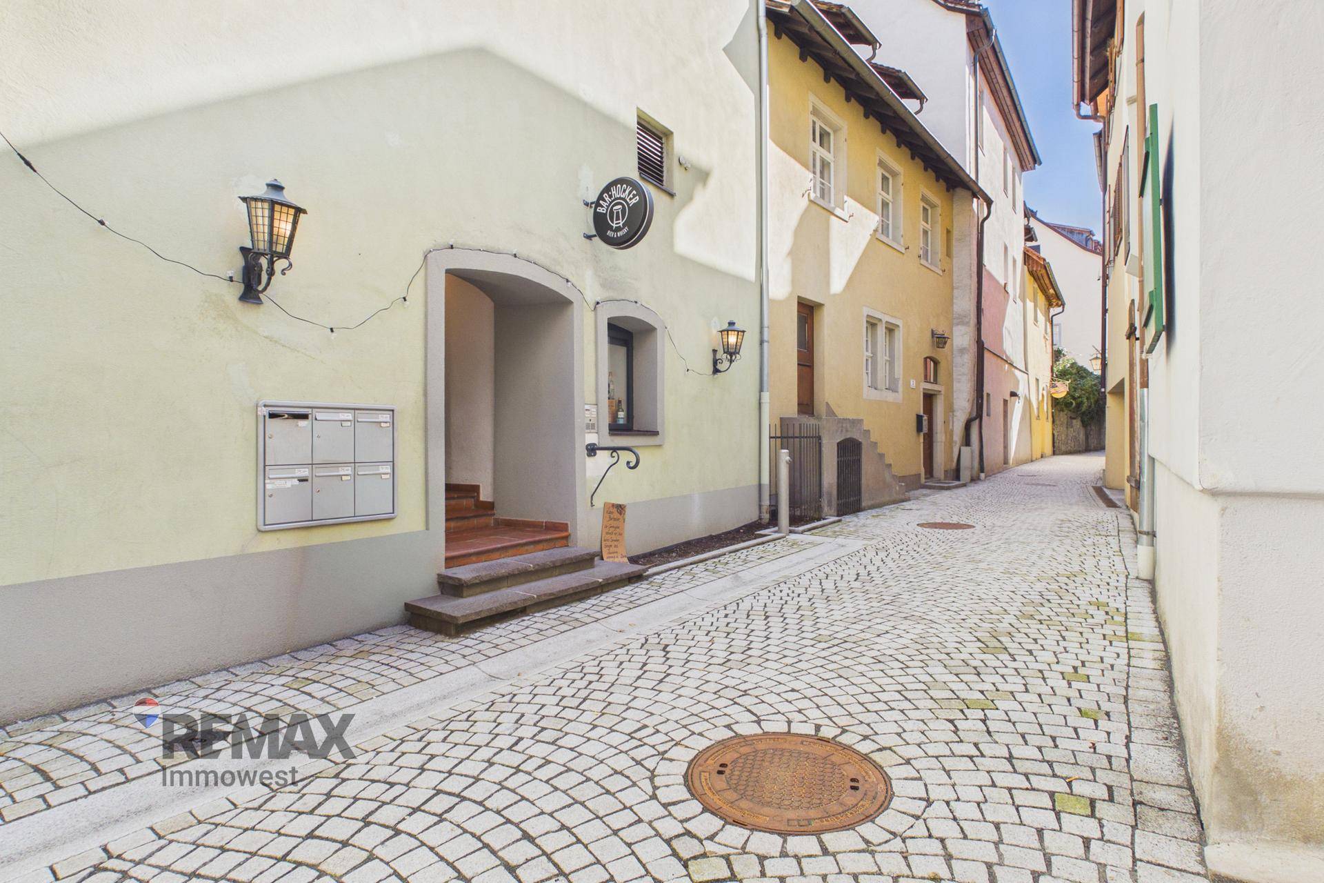 Historische Gasse mit Kopfsteinpflaster und einem charmanten Gebäudeeingang in einer Altstadt.
