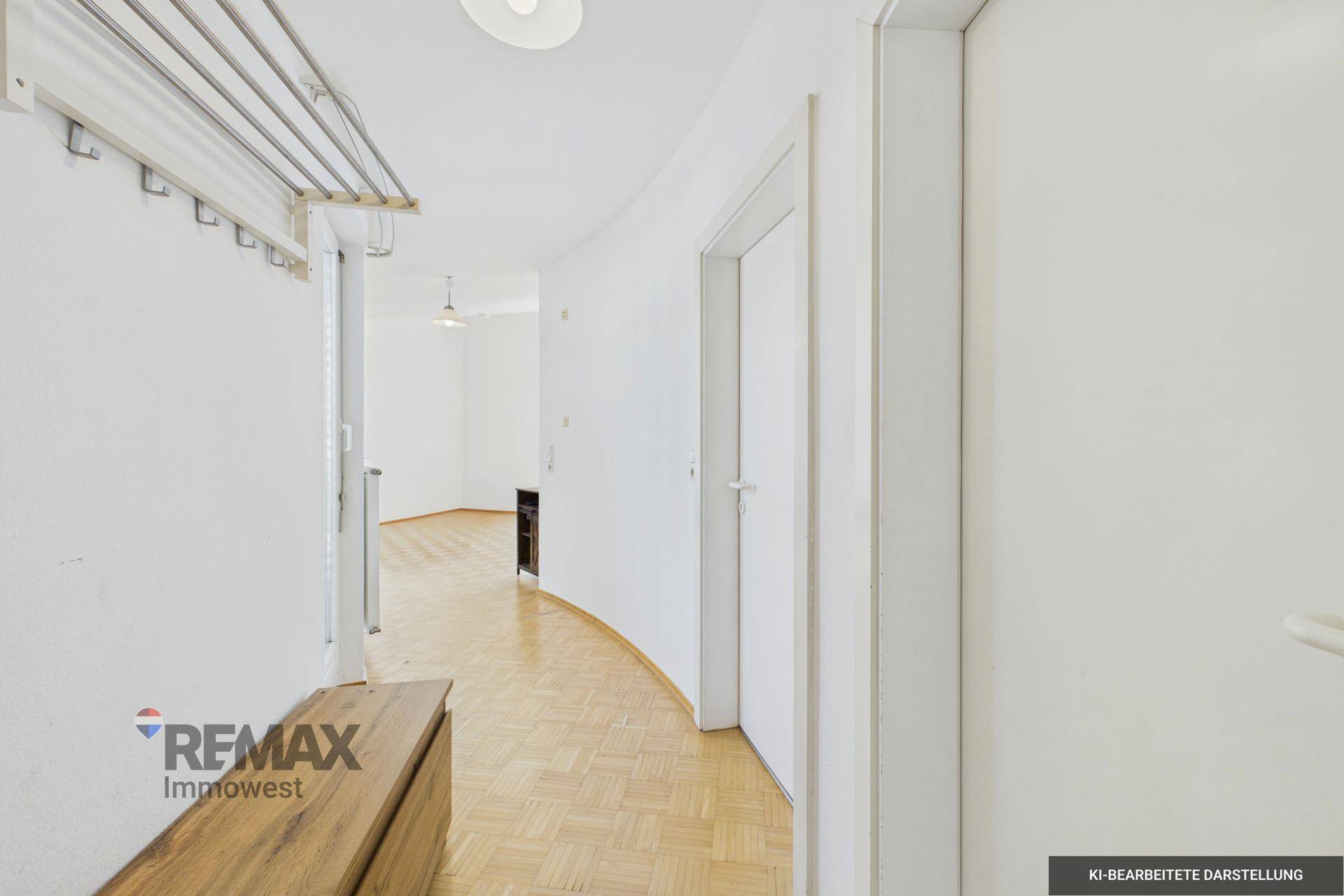 Heller Flur mit Parkettboden und Garderobe, der zu weiteren Räumen führt.