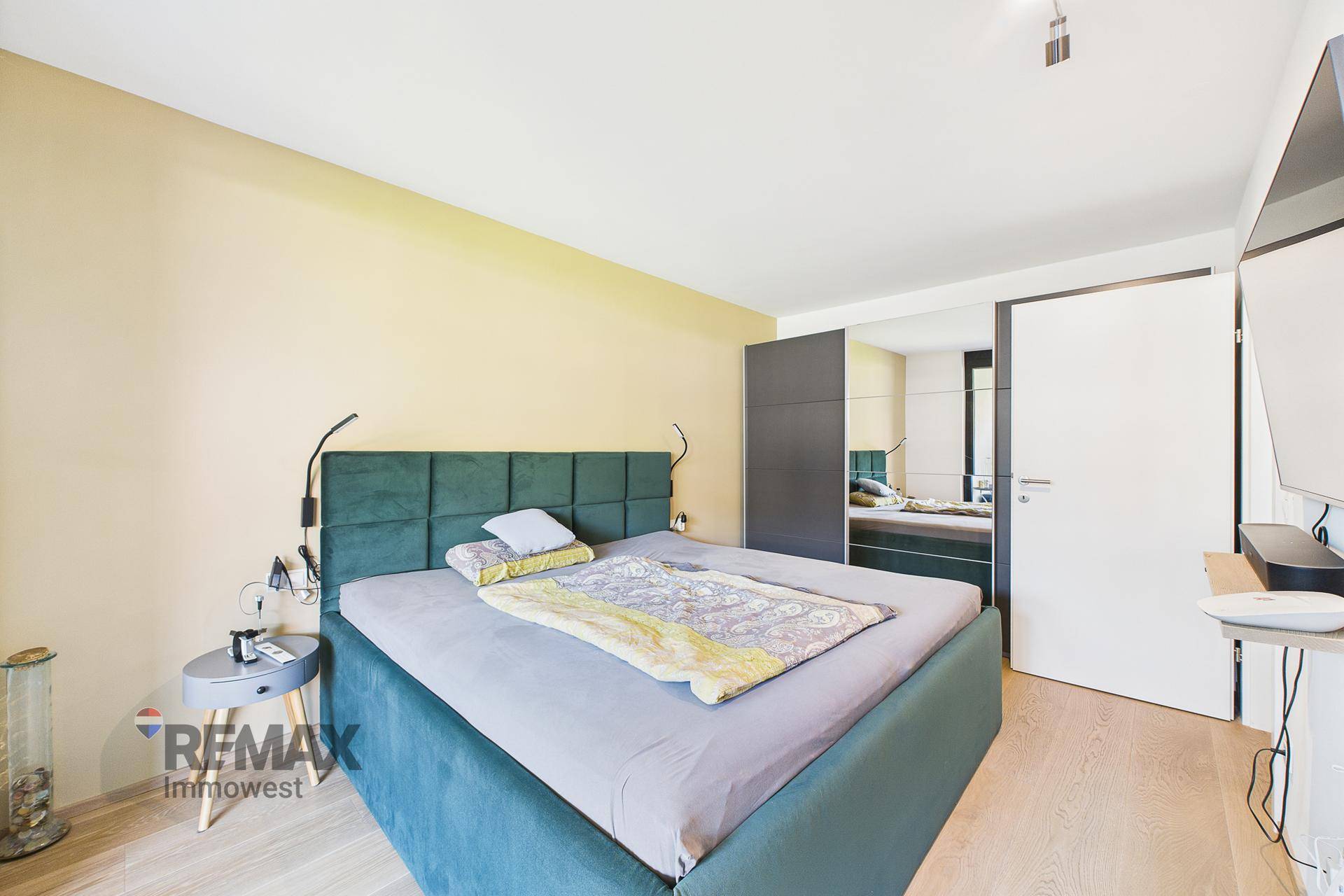 Gemütliches Schlafzimmer mit großem Doppelbett, Holzboden und hellem Ambiente.