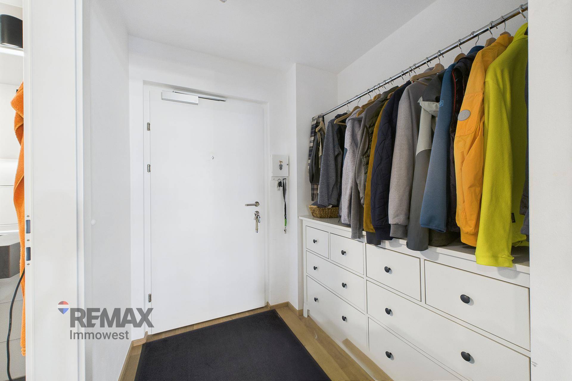 Heller Eingangsbereich mit Garderobe und praktischen Schubladenschränken.
