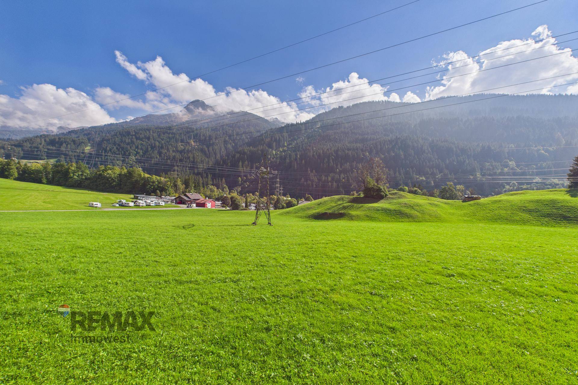 Weitläufige grüne Wiese mit Bergblick, ideal für Erholung und Freizeitaktivitäten im Freien.
