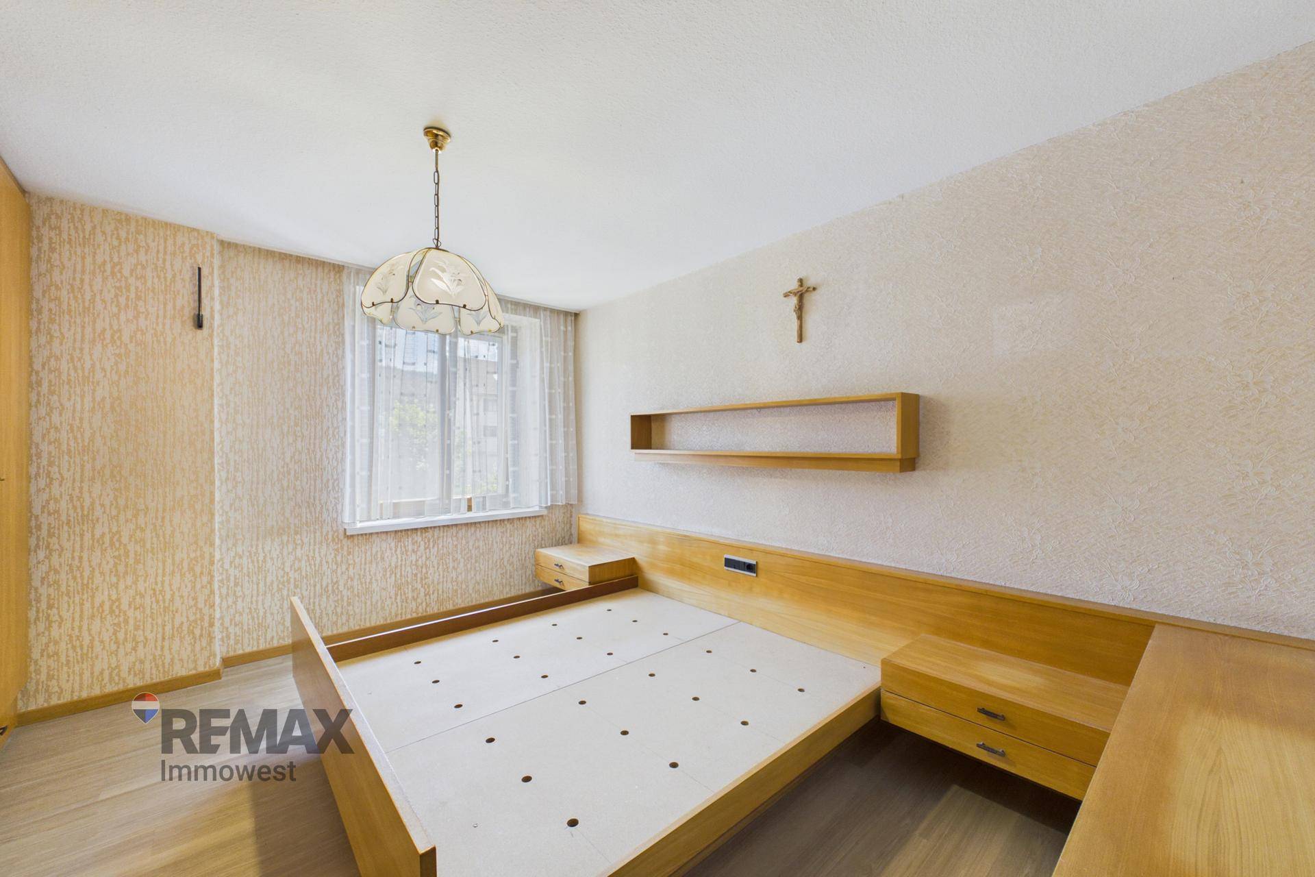 Schlafzimmer mit Holzbettrahmen, Nachttischen und strukturierten Tapeten, bietet eine ruhige Atmosphäre.