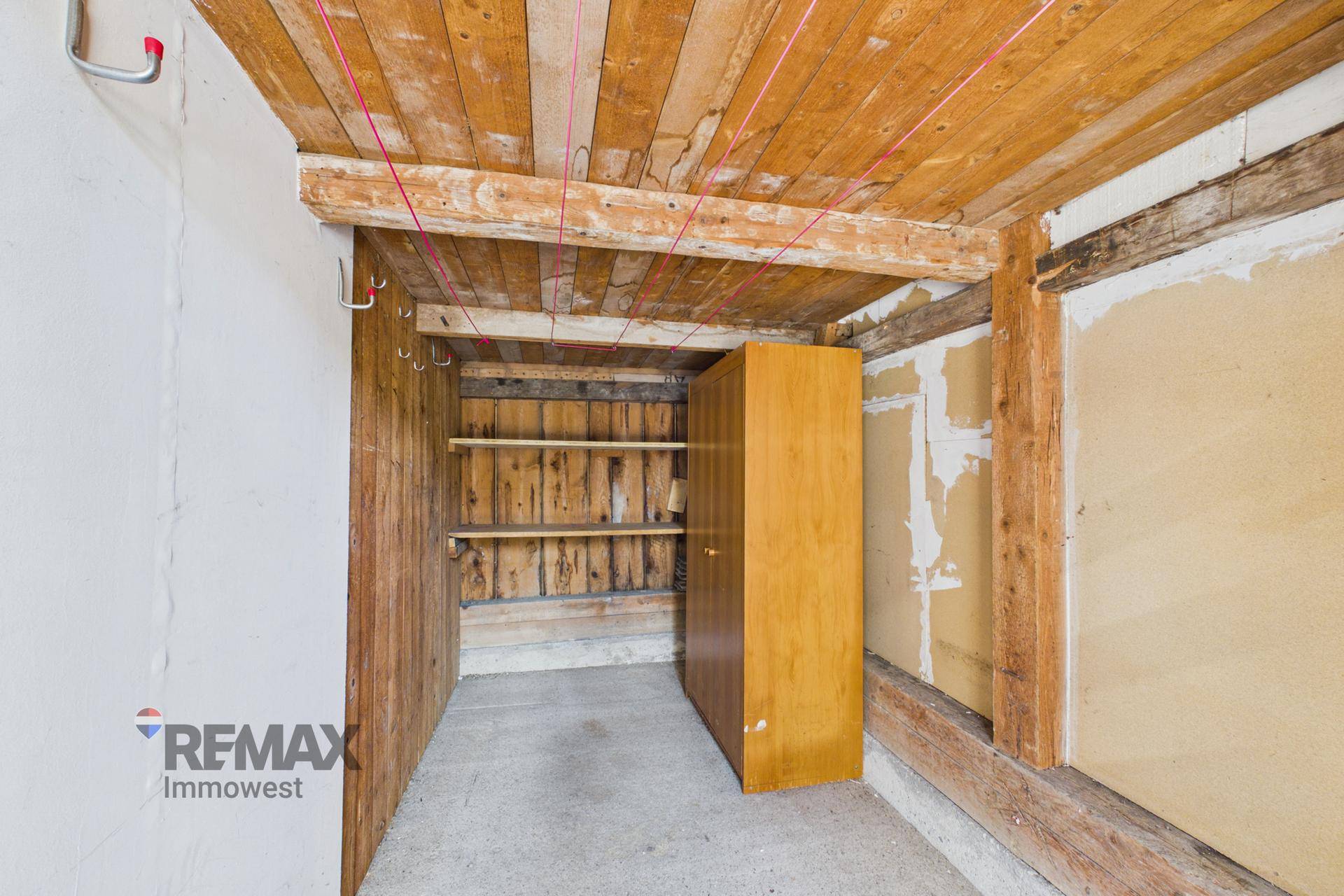 Lagerraum mit Holzdecke, Regalen und Betonboden, ideal für Werkzeuge und Vorräte.