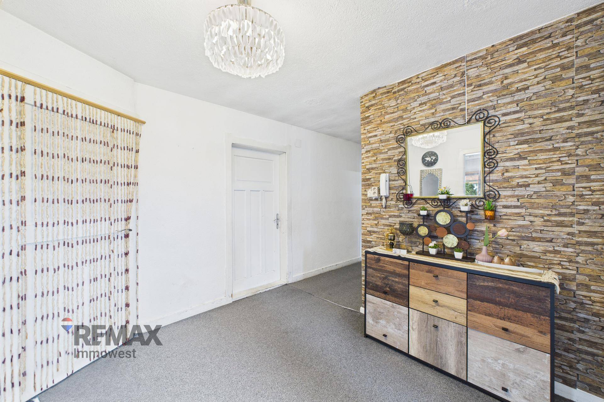 Eingangsbereich mit Steinwand-Akzent, modernem Sideboard und dekorativem Spiegel.