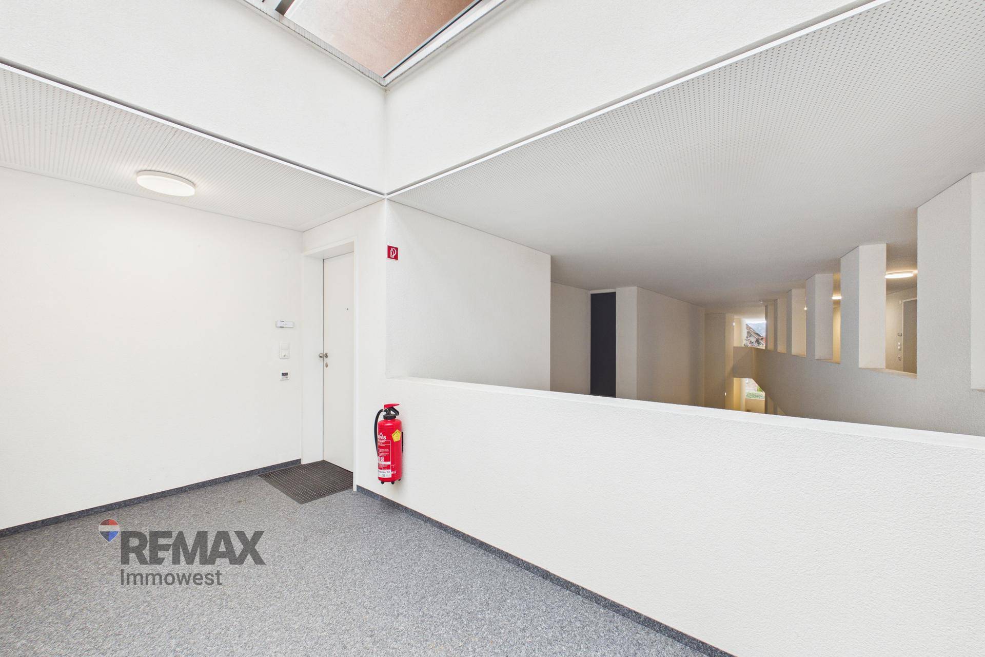 Heller Flur im Treppenhaus mit modernem Design und natürlichem Lichteinfall von oben.