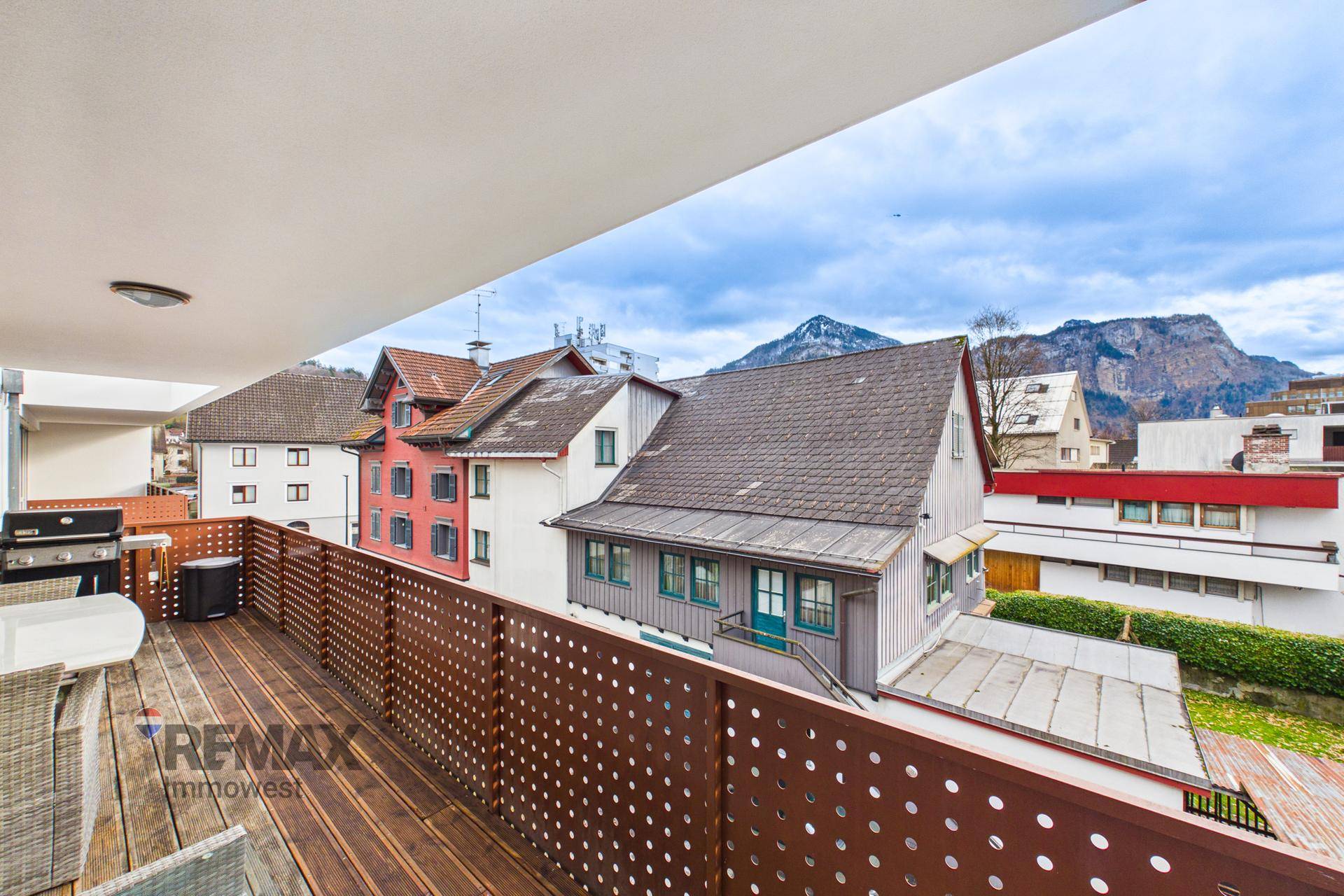 Großer Balkon mit Bergblick, Grill und Sitzgelegenheiten für entspannte Stunden im Freien.