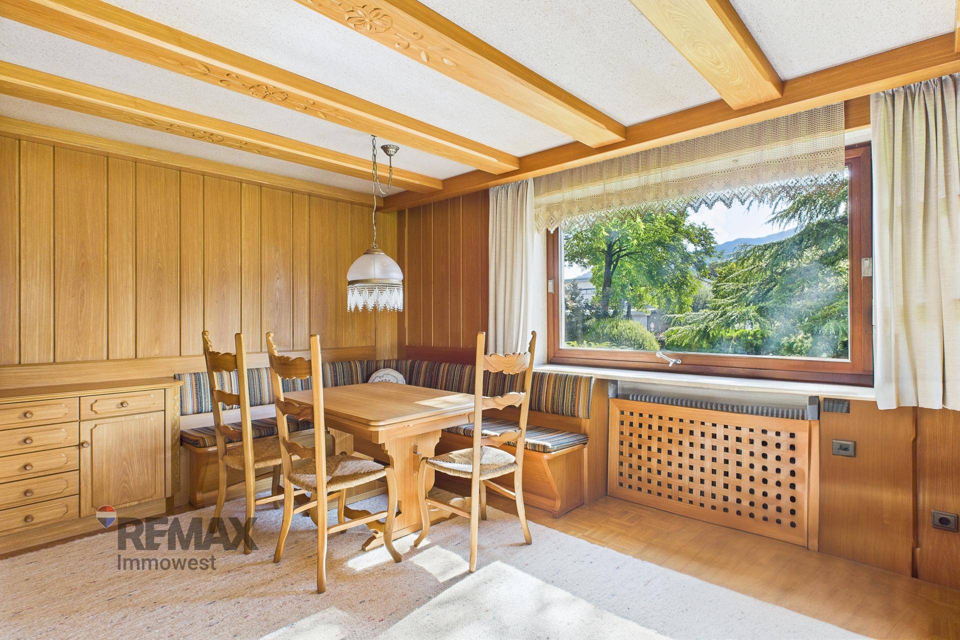 Traditioneller Essbereich mit Holztisch, Eckbank und Blick auf die umliegende Landschaft.