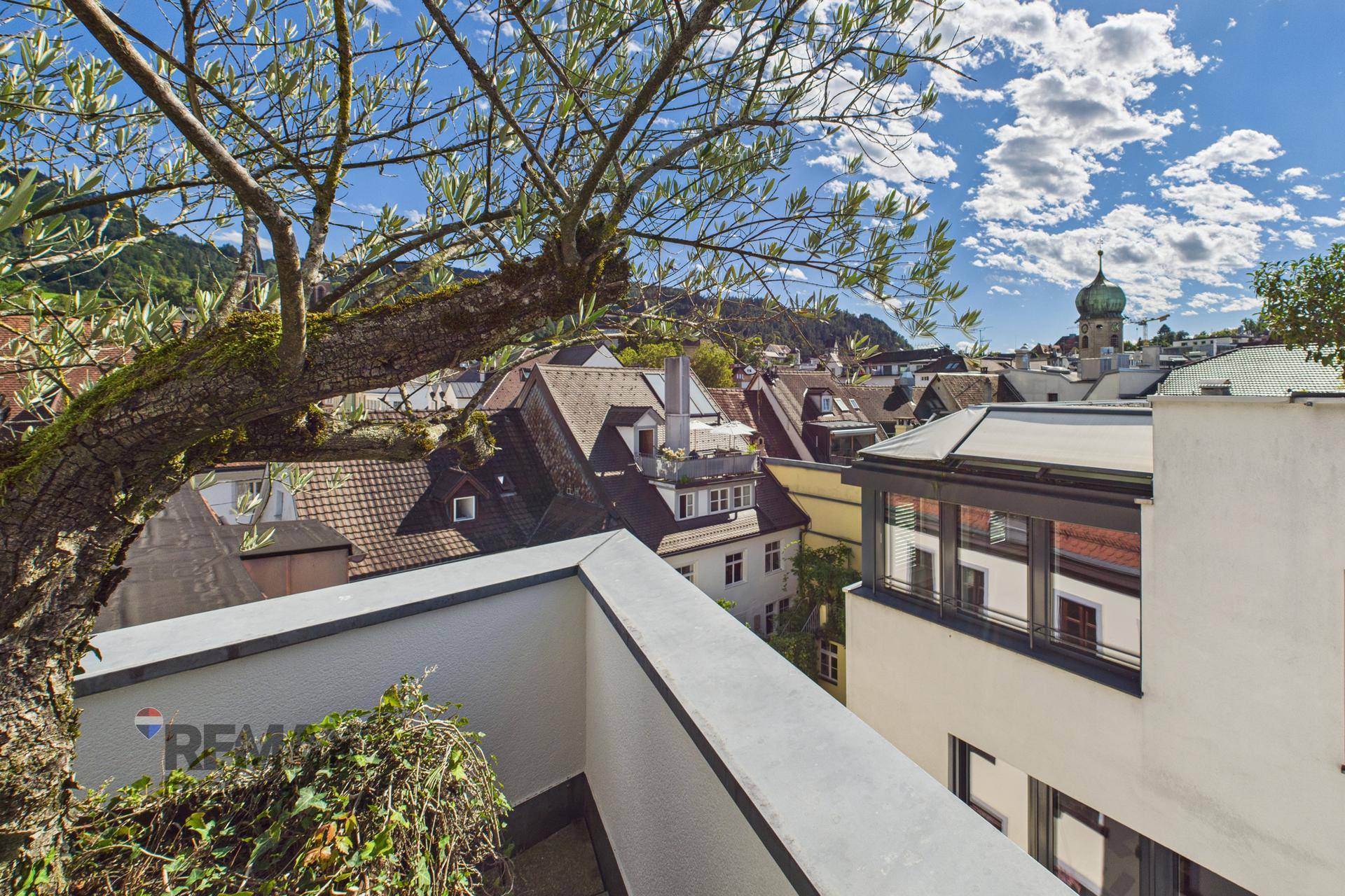 Malerischer Ausblick von der Terrasse auf die Dächer der Stadt und die umliegende Landschaft.
