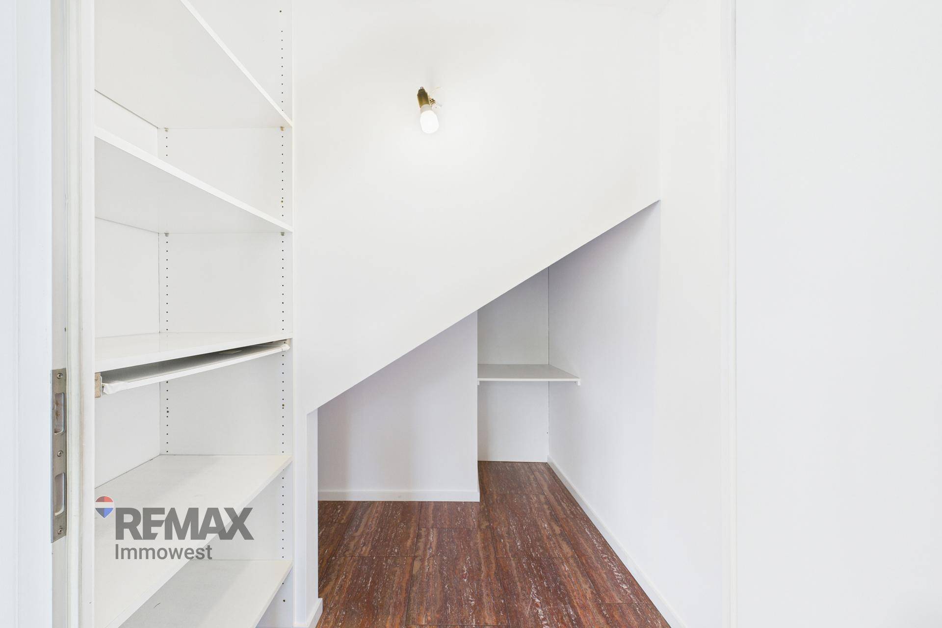 Praktischer Abstellraum unter der Treppe mit Regalen für zusätzlichen Stauraum.