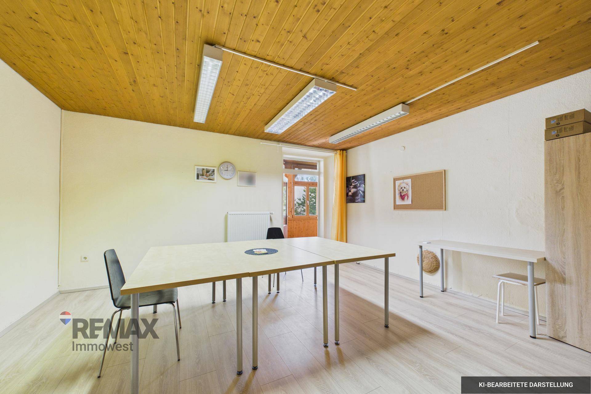 Heller Büroraum mit Holzlattendecke und modernem Laminatboden, ausgestattet mit Tischen und Stühlen.